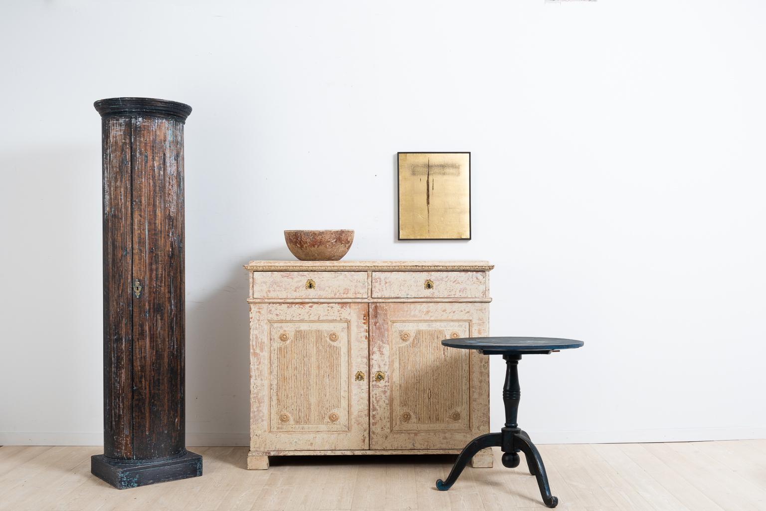 Double doored Gustavian sideboard with dry scarped to original paint. The doors are decorated with panels of fluted decor and carved circles. The lock and key are original and in fully functional condition. Manufactured in the middle of Sweden,