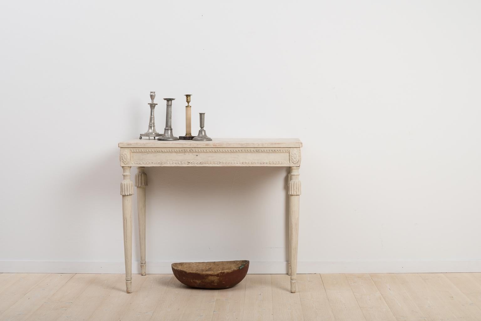 Swedish Gustavian console table from northern Sweden, Hälsingland manufactured circa late 1700s. With carved wooden decorations along the rim. The table’s back long side is not decorated as it was meant to be standing against a wall.