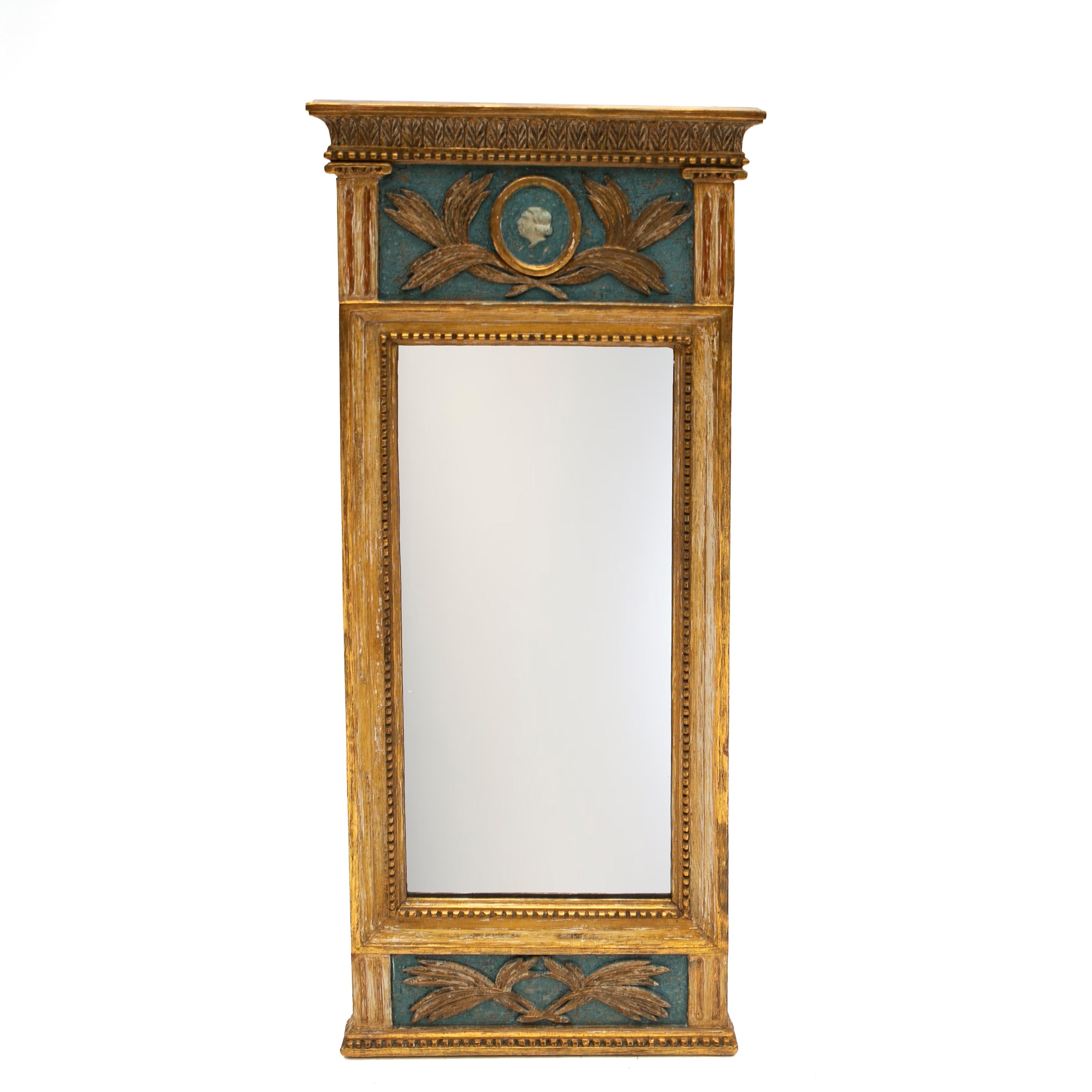 Antique Swedish rectangular wall mirror made of handcrafted giltwood, in good condition.
Frame enhanced by softly painted blue background and hand-carved elements, upper section of the mirror is adorned with a gesso head medallion in profile and