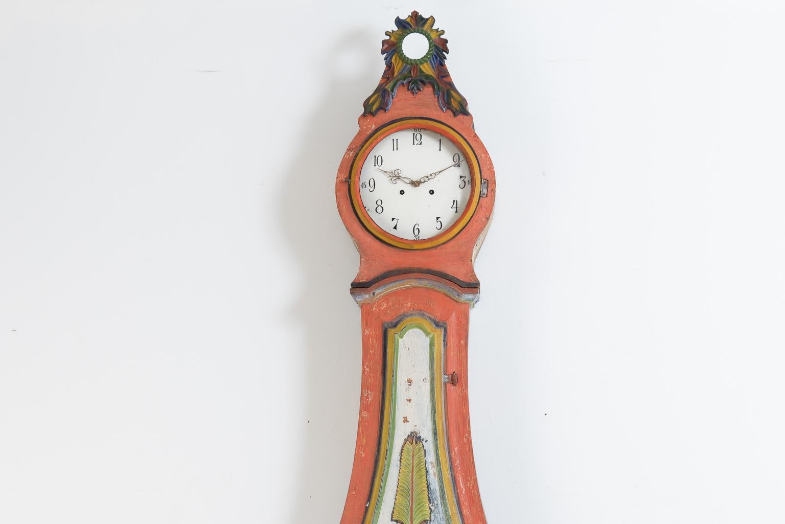 Gustavian model long case clock from northern Sweden. All the embellishments are carved wooden decorations. The clock mechanism is serviced and functional at the time of writing but we cannot provide any guarantees for future function. The clock has