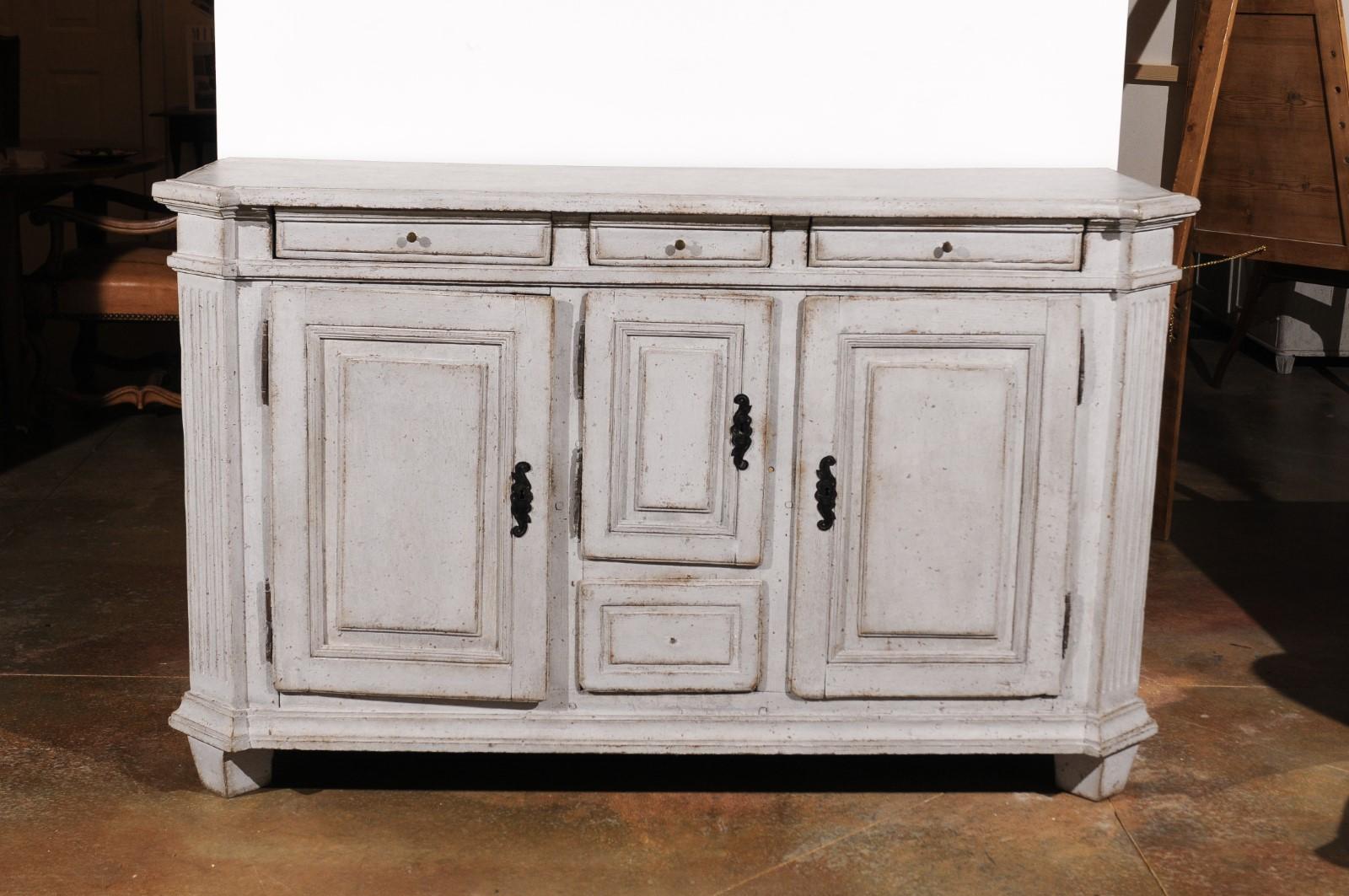 A Swedish Gustavian period painted wood sideboard from the late 18th century, with canted side posts, four drawers and three doors. Born in Sweden during the early years of King Gustav III's reign, this painted sideboard features a rectangular top