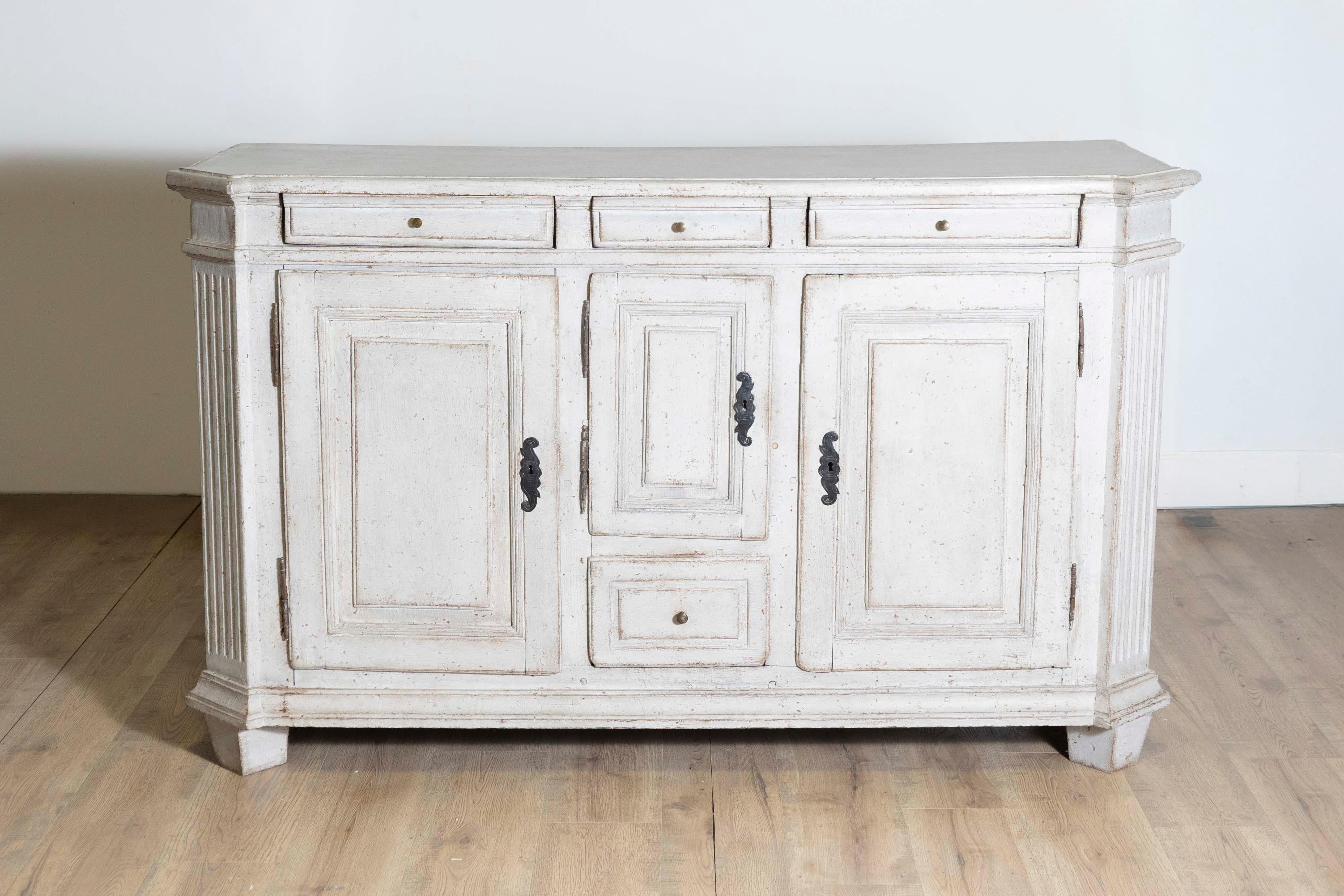 A Swedish Gustavian period painted wood sideboard from the late 18th century, with canted side posts, four drawers and three doors. Born in Sweden during the early years of King Gustav III's reign, this painted sideboard features a rectangular top