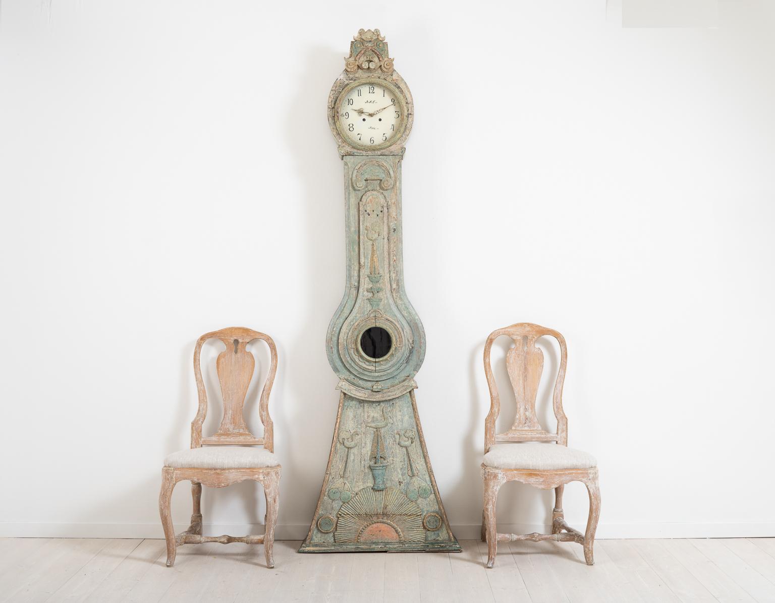 Long case clock from Norrbotten in northern Sweden. The clock is manufactured circa 1790-1800 and made from painted Swedish pine. Dry scarped to the original light turquoise paint. The clock is decorated with unusual carved wooden decorations such