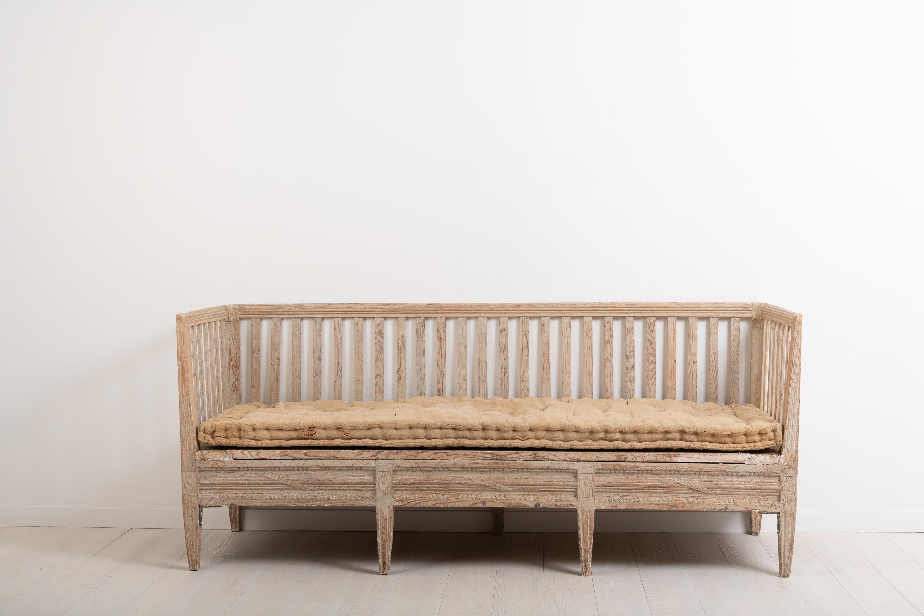 Antique sofa bench from the late 18th century. The bench is neoclassic and made in Sweden circa 1770. It is decorated with carved wooden decorations typical for the neoclassic period. Original and distressed paint from the 1770s. Natural patina. One