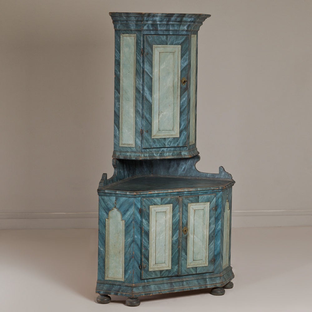 A superb late 18th century two-part Swedish corner cupboard in a blue veined marble paint finish.
The cupboard is furnished with brass wear and set on bun feet.
It retains its original shelving to the interior.