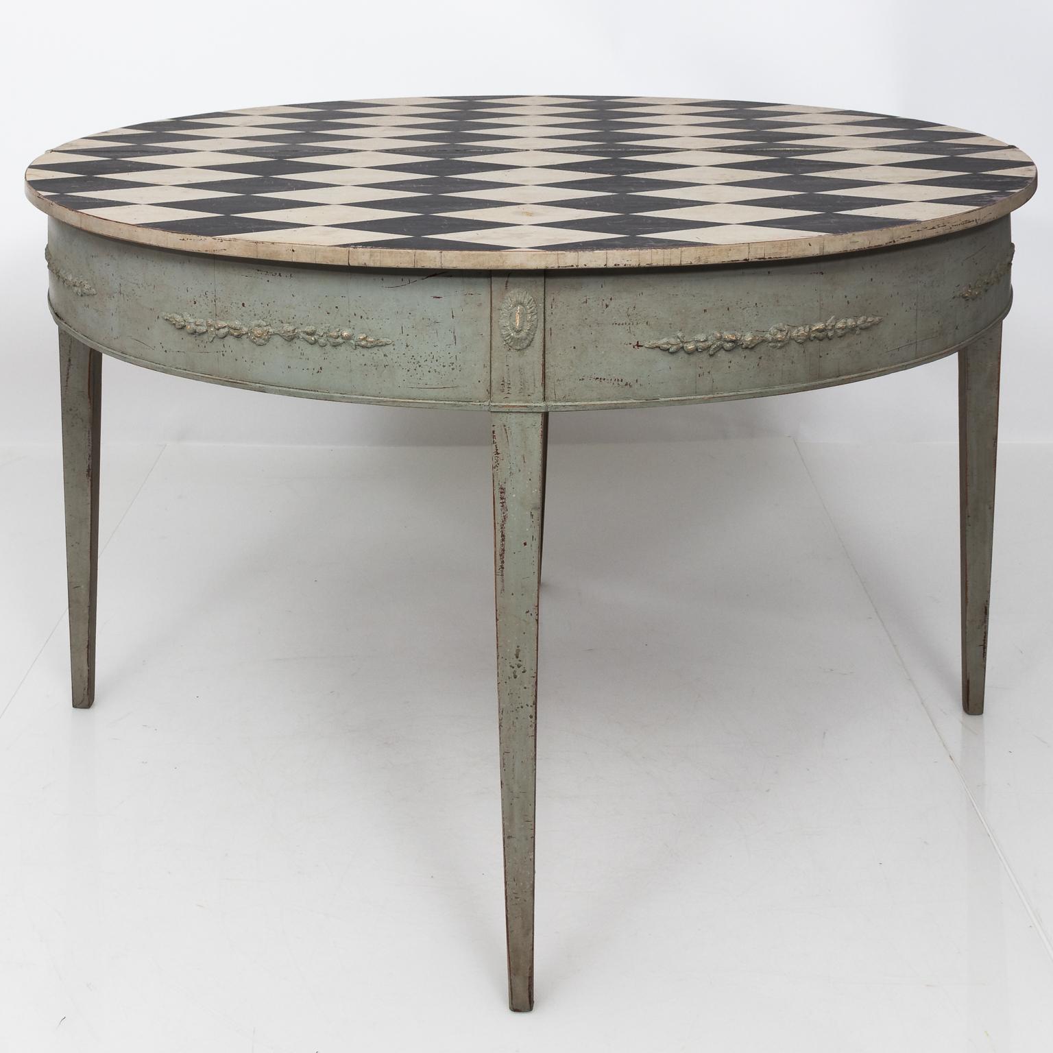 Late 1700s round drop leaf Gustavian style table with black and white parcquet diamond pattern work on the table top and plain tapered legs.
 