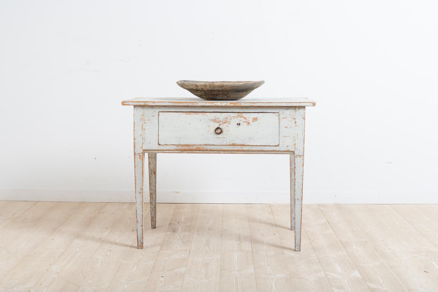 Late 18th century side table from northern Sweden. The table is provincial Gustavian and the frame is healthy and solid. Dry scraped to the original first layer of paint. With straight legs and a large drawer. The table works well as a side table
