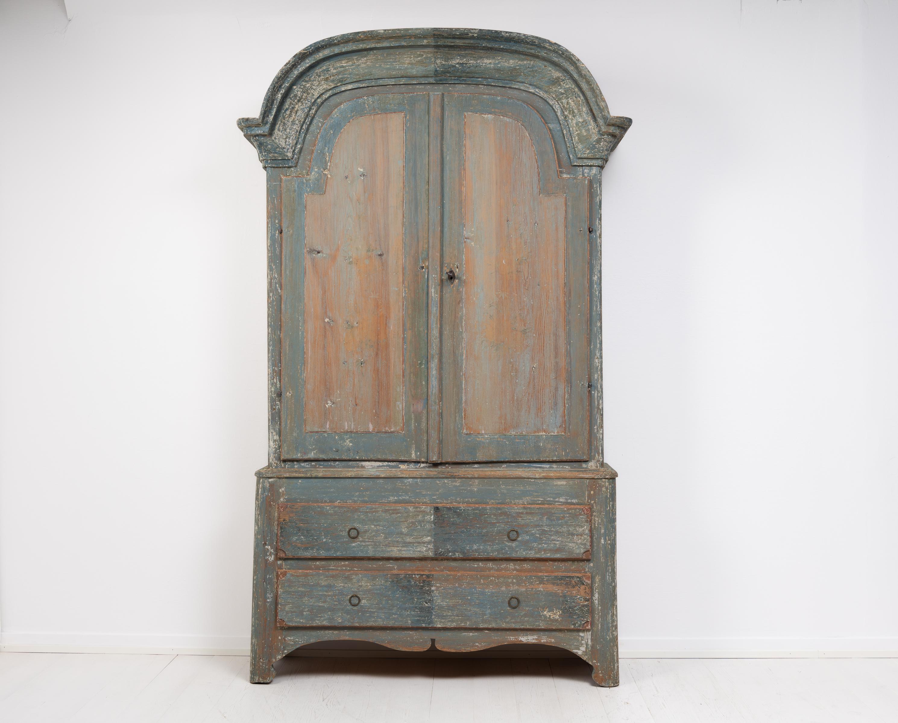 Rare Swedish rococo country cabinet in painted pine. The cabinet is a classic country house furniture from northern Sweden. Made during the late 18th century, circa 1790, during the rococo period. The cabinet is made in two parts and has a healthy