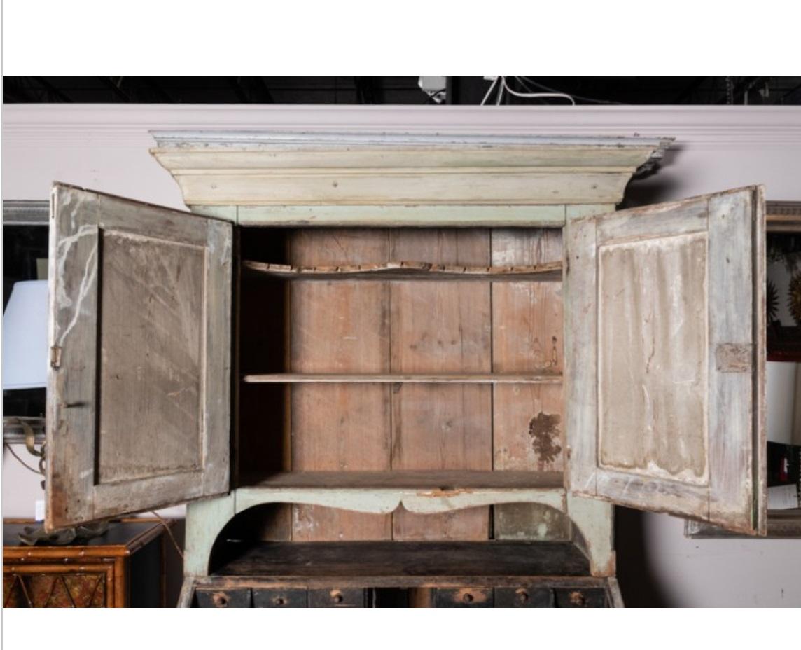 Splendid early antique Gustavian style secretary cabinet, made in Sweden, circa late 19th century. This rustic cabinet retains its historic paint--a soft blue faded beautifully with age. Fold-down desk features eight pigeonhole cubby with