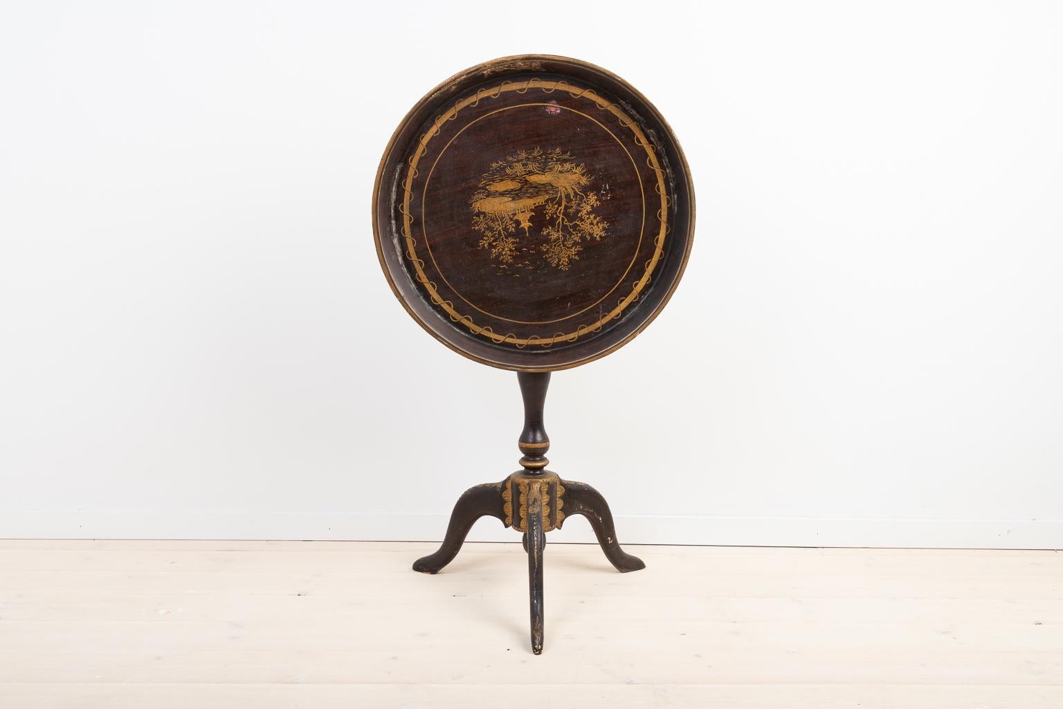 Schwedischer Tabletttisch des späten 18. Jahrhunderts. Der Tisch ist mit Holzschnitzereien verziert. Ein witziges Detail ist, dass das Bild auf der Tischplatte auf dem Kopf steht, wenn es zusammengeklappt ist. Der Tisch ist leicht schief - siehe