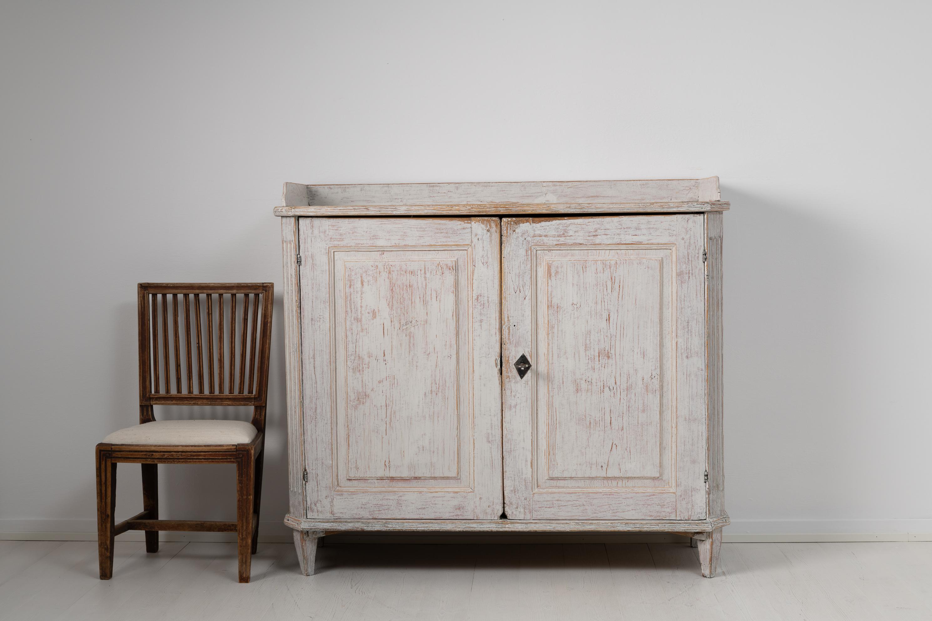Northern Swedish white country home gustavian neoclassical sideboard. The sideboard is from the late 1700s and has a straight model with two doors. It has all the classic gustavian characteristics with angled corners with three flutes and straight