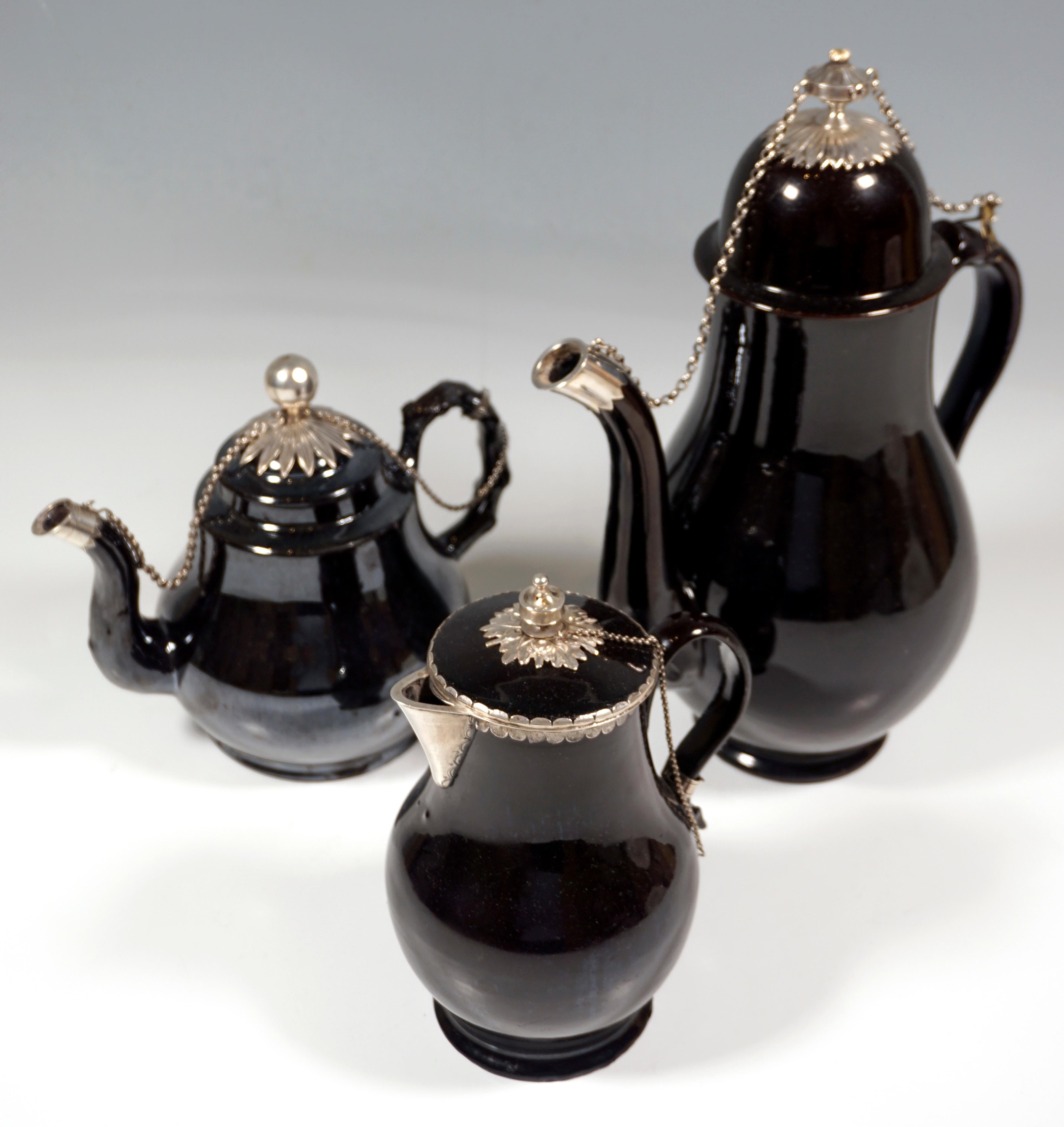 Dreiteiliges Kernstück bestehend aus Kaffeekanne, Teekanne und Milchkännchen aus Terre de Namur-Keramik.

Terre de Namur
Die feine schwarze Fayence ist ein besonderes Produkt aus Namur, Belgien, Ende des 18. Jahrhunderts. Es handelt sich um eine