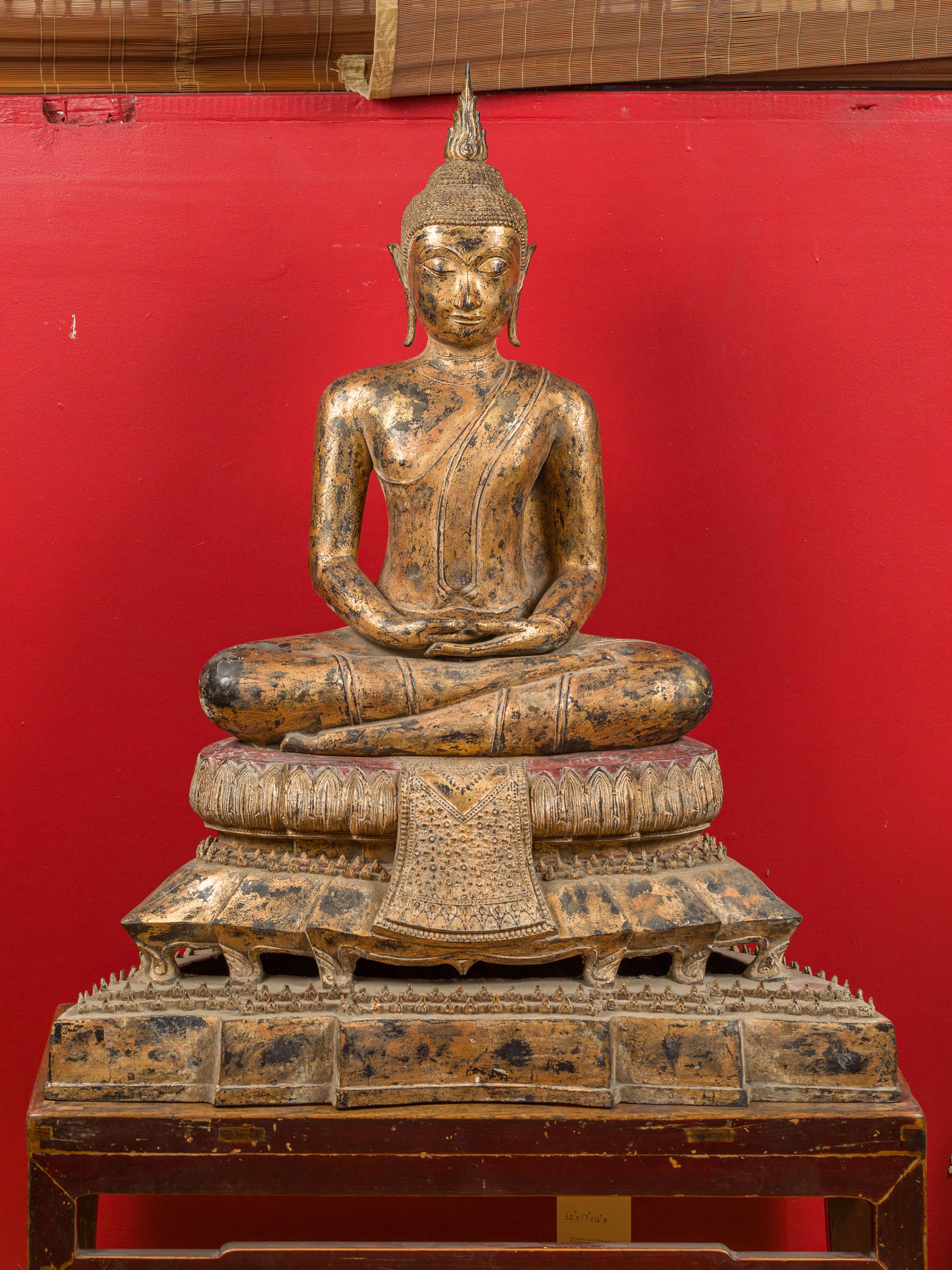 A Thai Bangkok period seated Buddha statue from the late 18th century, handcrafted out of bronze and gilded. Born in Thailand during the 1780s, this tall statue features a seated, meditative Buddha, accented with exquisite details. The pedestal in