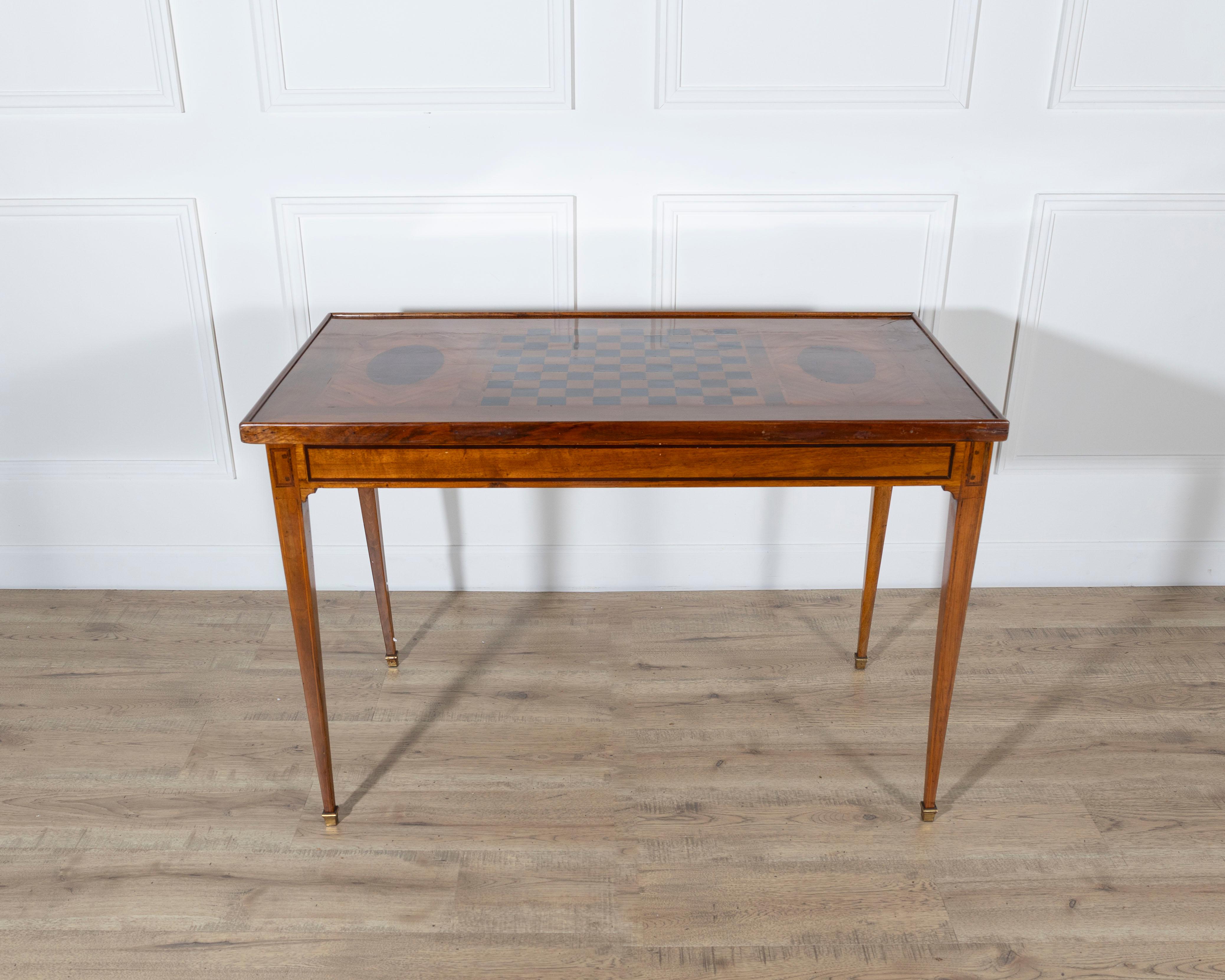 This late 18th-century tric trac table is constructed in varnished marquetry with a removable reversible top. One side features marquetry in geometric and oval motifs, while the reverse is covered in a recently added green felt playing surface.