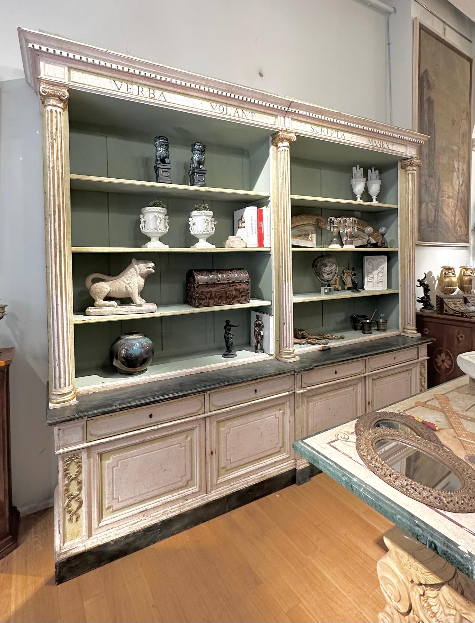 Large open bookcase with two bodies in painted chestnut wood with a chalky background and lean tempera. Pastel colors and carved and gilded refinishing with pure gold leaf. The structure is divided into four parts, but is characterized by an upper