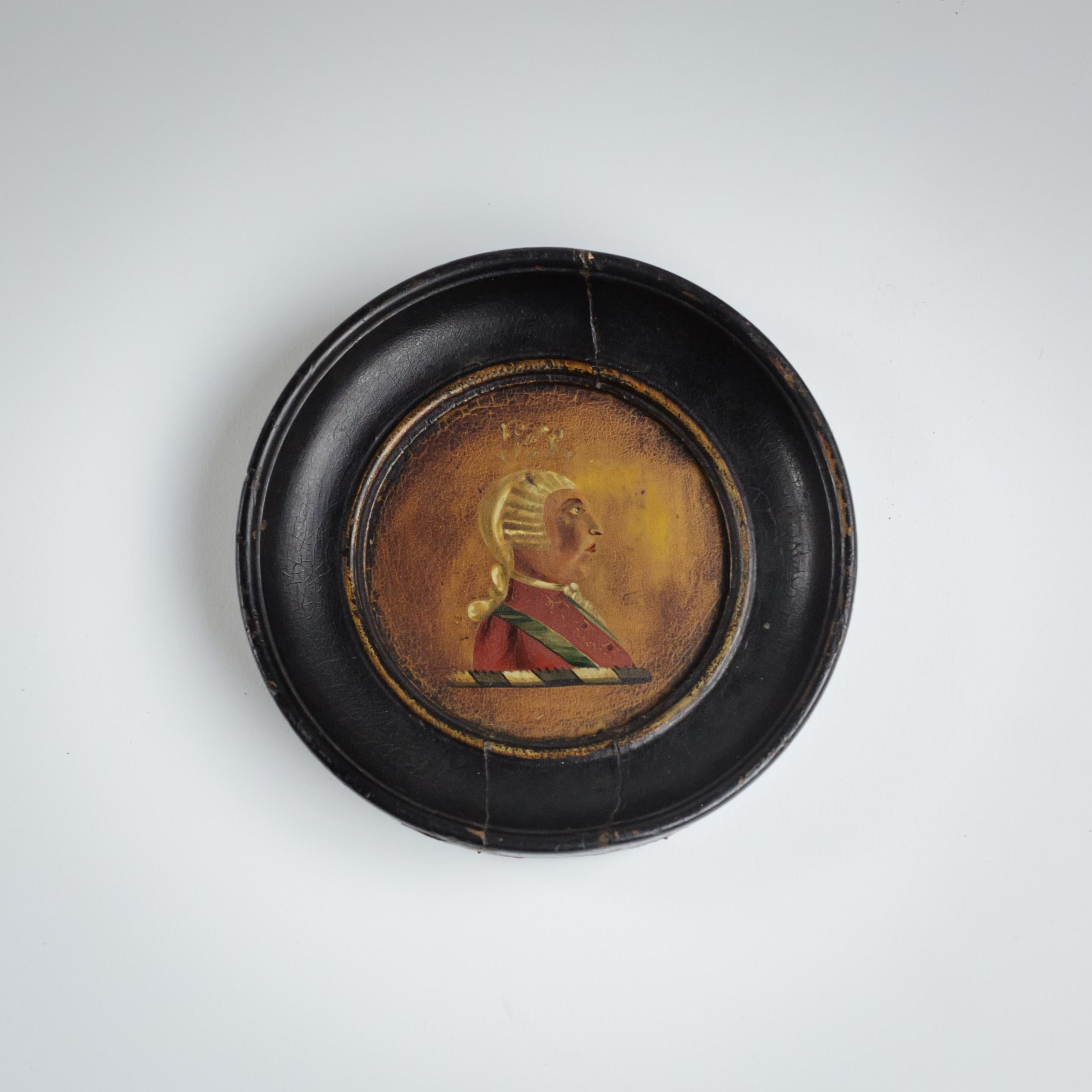 Dieses kleine Öl-auf-Karton-Porträt zeigt ein Profil von König Georg III. (1738-1820), das in einer vereinfachten, aber eindrucksvollen Art und Weise dargestellt ist, die typisch für die volkstümlichen britischen Porträtminiaturen der späten