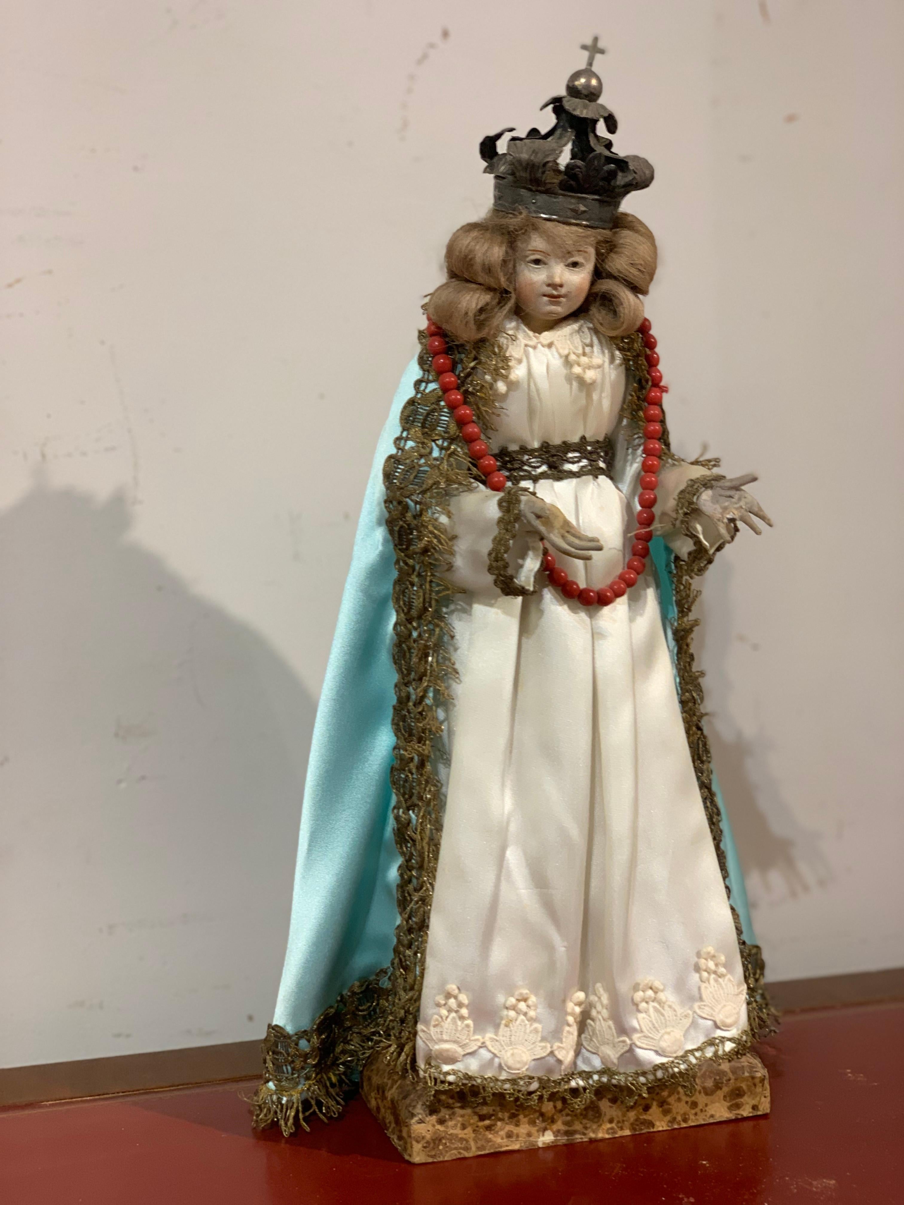 Belle figure votive représentant la Madone avec des vêtements de soie et une couronne d'argent, sur une base en bois peinte à l'imitation du marbre.
Petit format, fabrication en Italie du Sud dans la seconde moitié des années 1700.

MESURES : h cm
