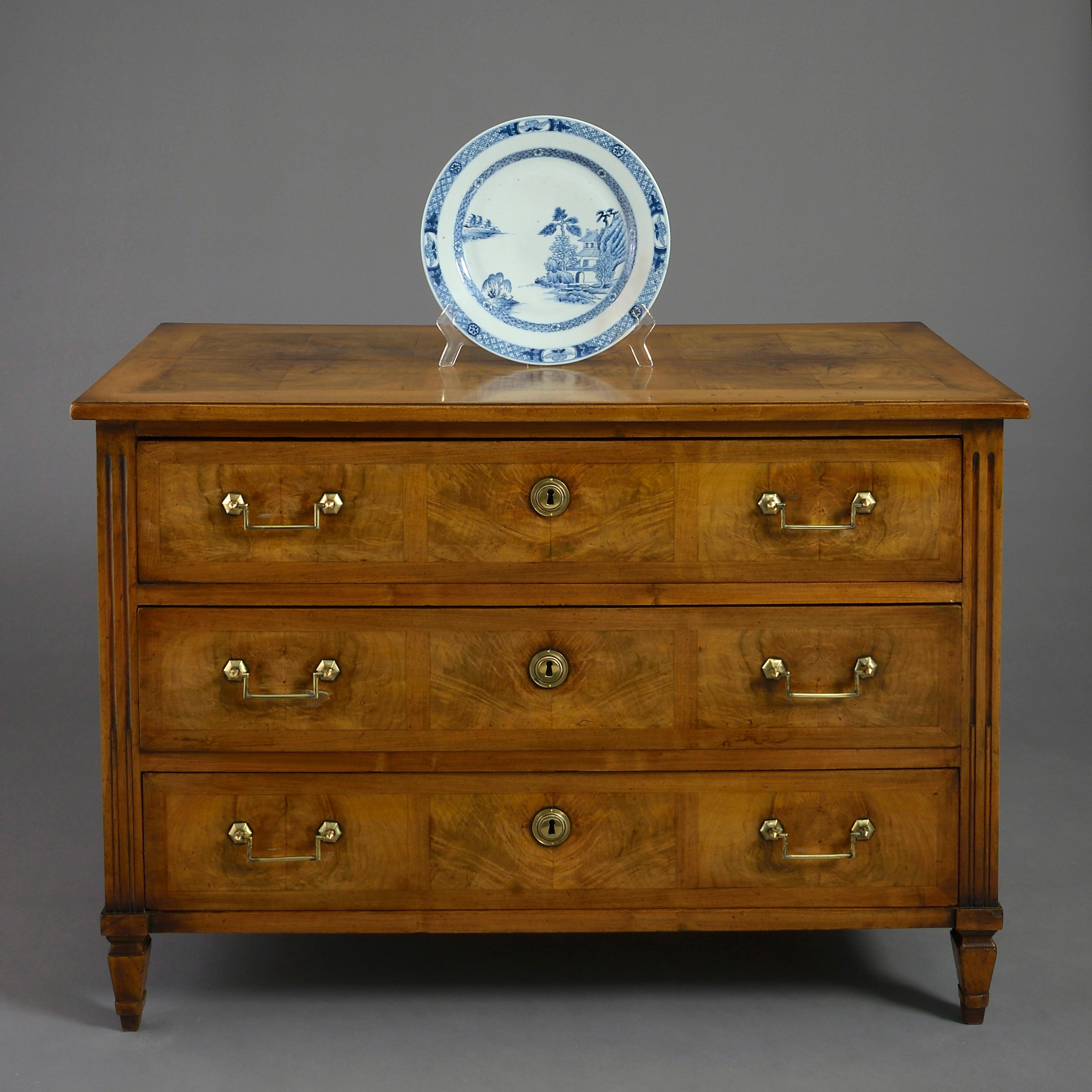 A good late 18th century walnut commode in the classical taste, with paneled veneers throughout, the three drawers with rectangular brass handles and medallion lock escutcheons and all raised on square tapering feet.
