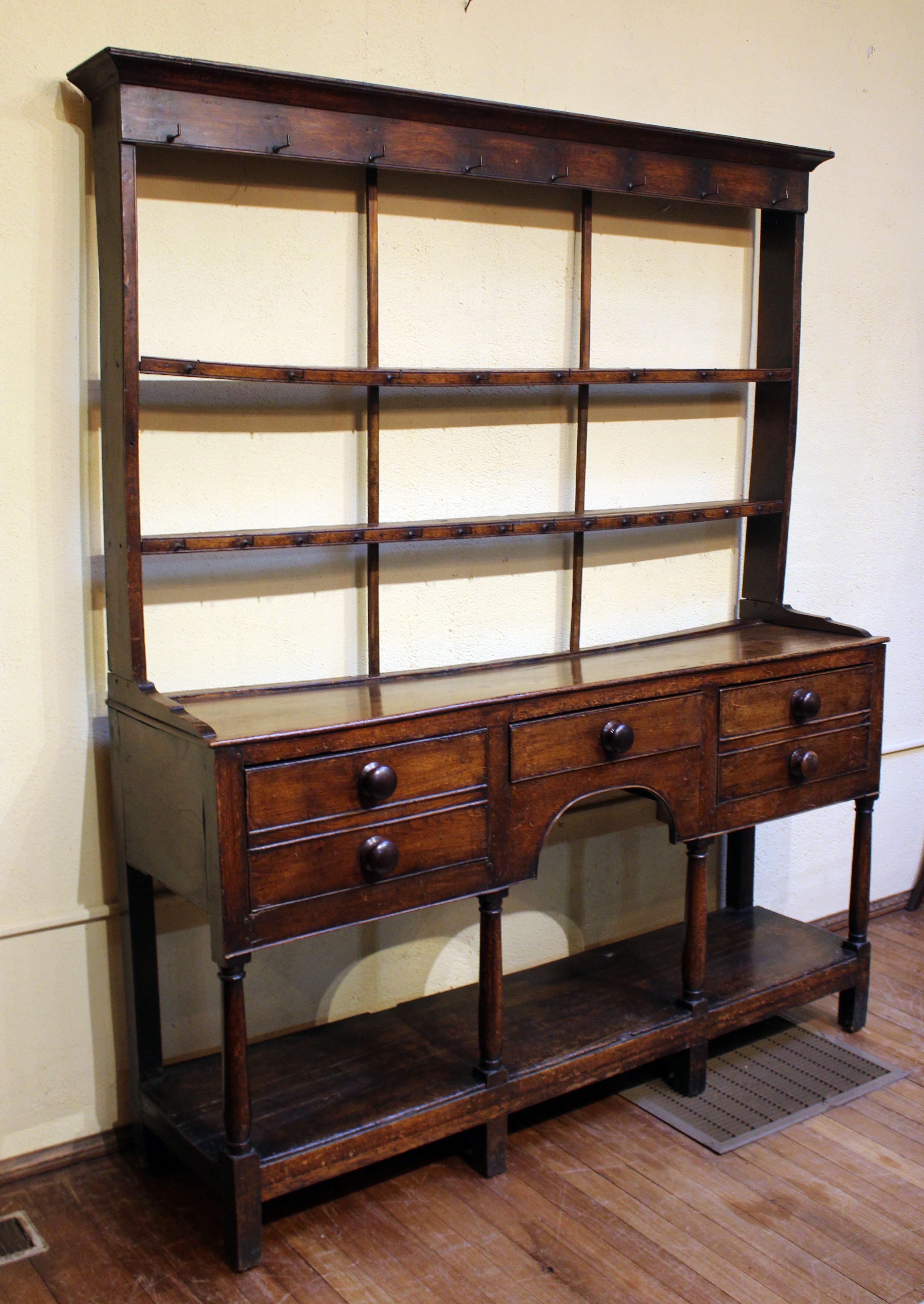 Comò gallese della fine del XVIII secolo con base a ripiano, Wales and Wales. Olmo e frassino. Le belle colonne sono semplicemente tornite. I cassetti profondi, con doppio frontale per dare continuità al design, sono affiancati da un cassetto