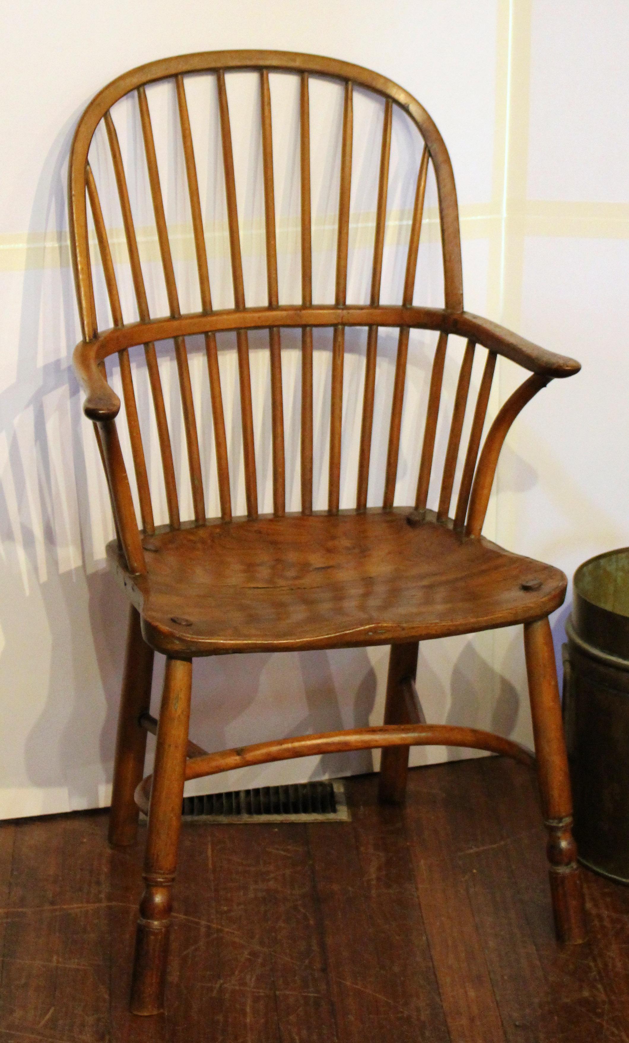 A late 18th century Windsor arm chair with a desirable crenoline stretcher and attractive, comfortable saddle seat. From Dorset, England. Formerly of the collection of Prof. and Mrs. Walter Smith of Dorset and Chapel Hill, NC. Minor flaws