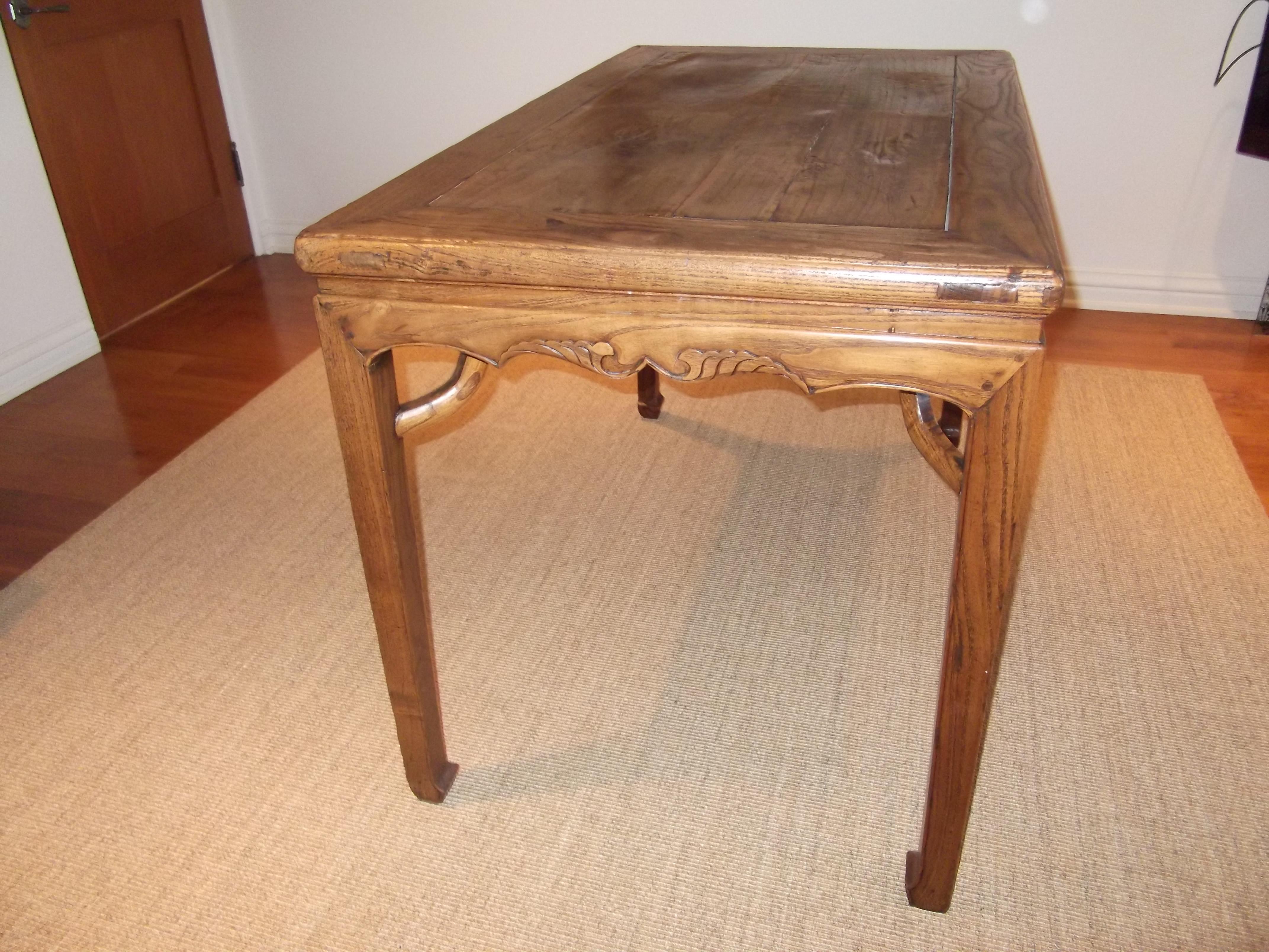 This is a rectangular painting table with ice plate edge frame member molding, supporting apron with floral carving, giant arm braces, square legs with beaded edging and inward square horse hoof feet. This table is constructed of mitered mortise and