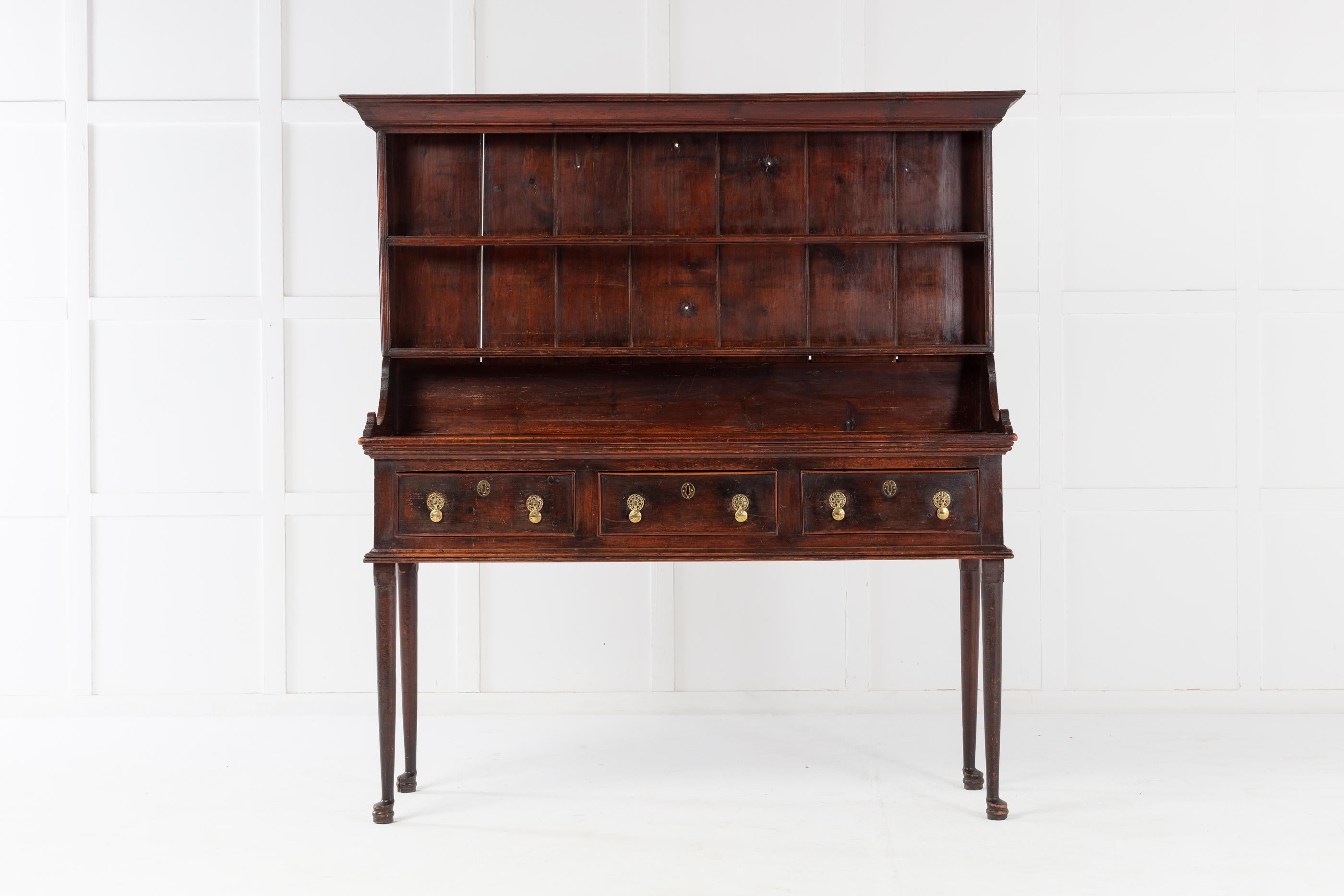 Late 18th/early 19th century pine dresser with its original rack, with moulded cornice and two plate shelves. Having three drawers. Supported by very unusual, high pad foot legs. Excellent original colour.

This is a really unusual dresser with