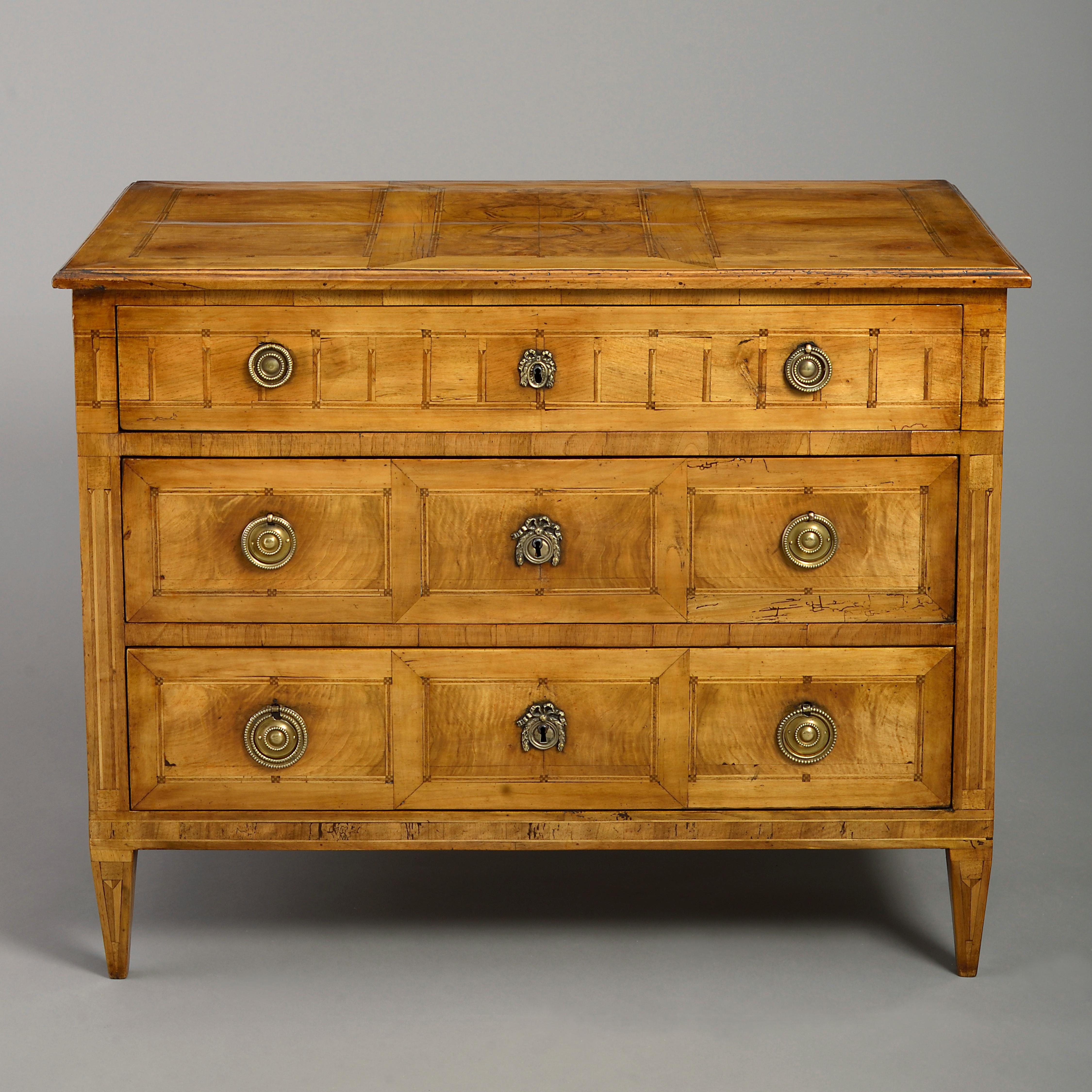 A late 18th century Louis XVI period neoclassical walnut veneered commode, the top with parquetry panelling above three drawers with of the same with brass lock escutcheons and medallion handles, terminating in square tapering feet.