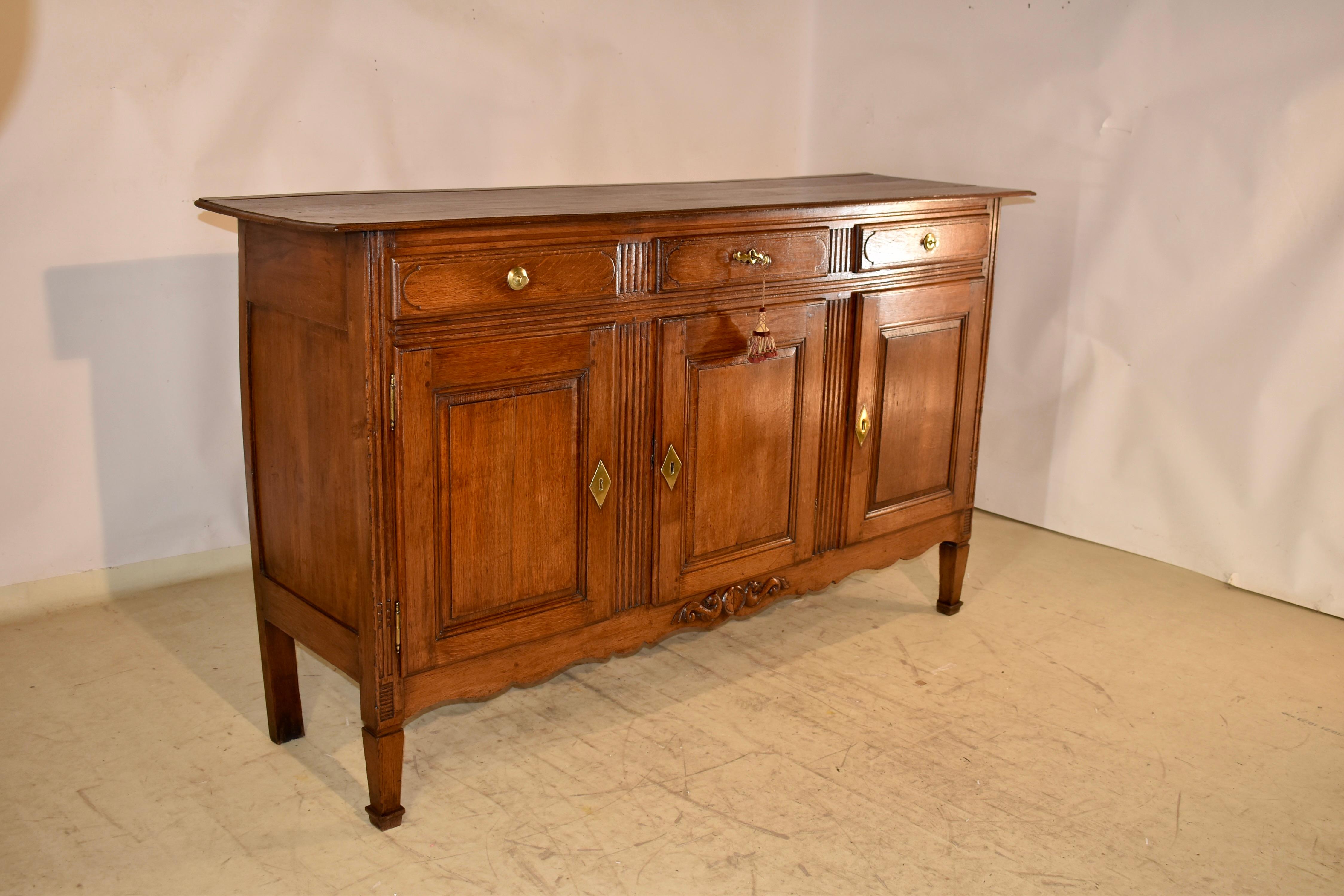 Enfilade in quercia della fine del XVIII/inizio XIX secolo proveniente dalla Francia.  Il piano è composto da tre tavole e presenta un bordo smussato che circonda il piano e un listello sul retro.  Per fissare la parte superiore alla base sono stati