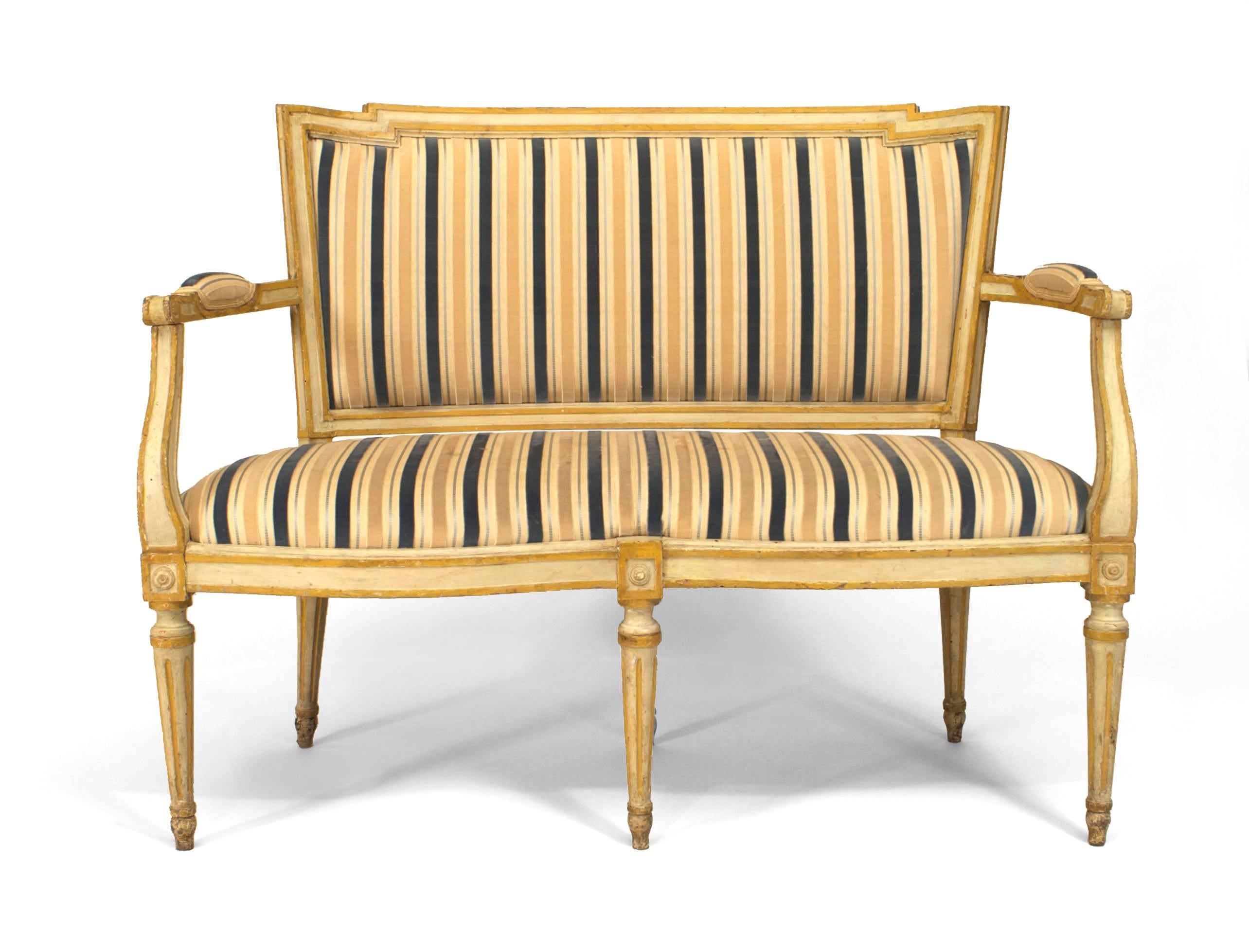 Italian Neo-classic (18/19th Cent) white painted and gold trimmed loveseat with a shaped front and center leg with striped upholstered seat and back
