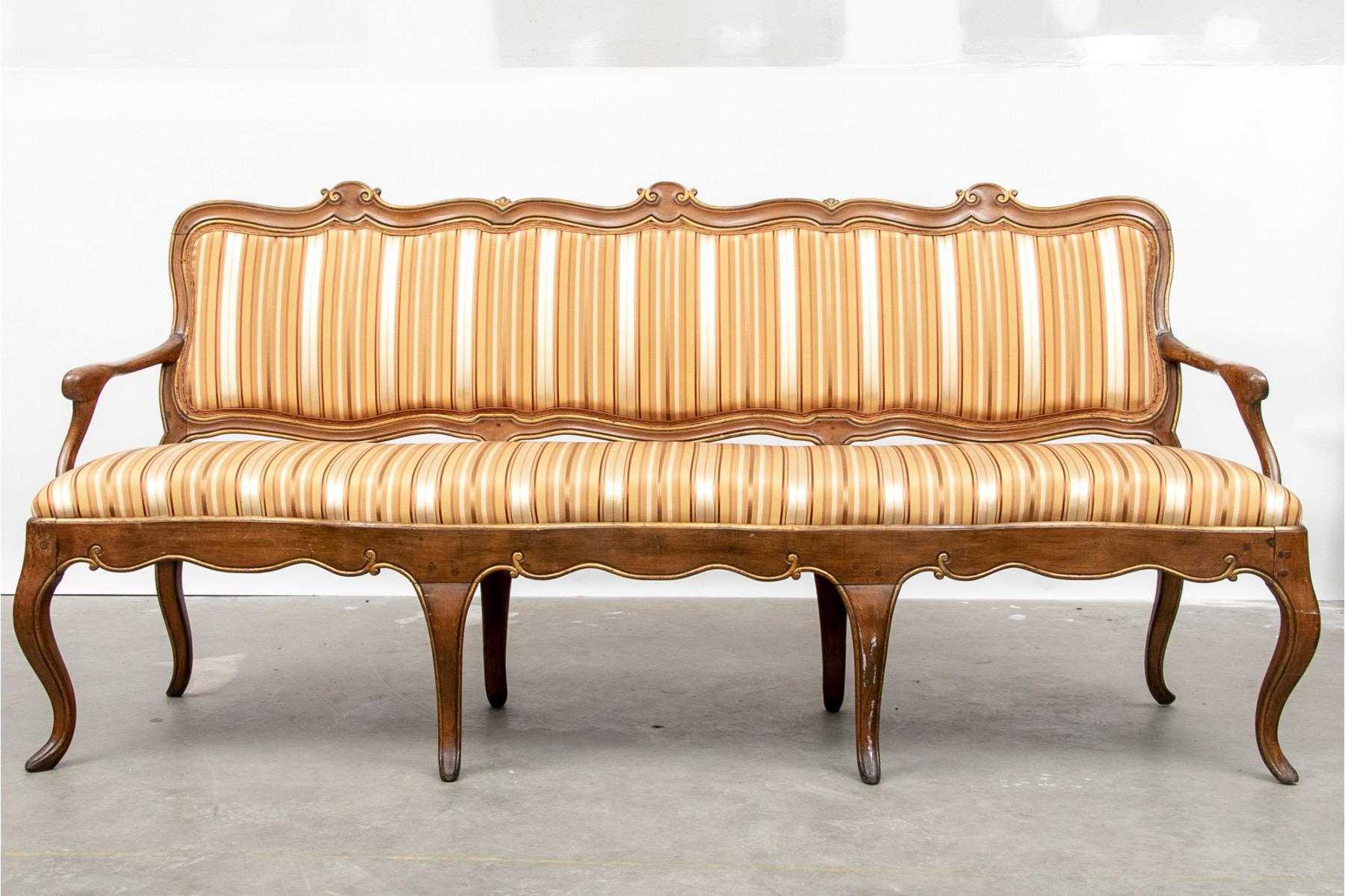 Late 18th century Swedish walnut sofa with traces of partial gilt. The hand carved frame has intricate decorations and a beautiful patina. The sofa is upholstered in a striped silk fabric. Good vintage condition, but is fragile and not intended for