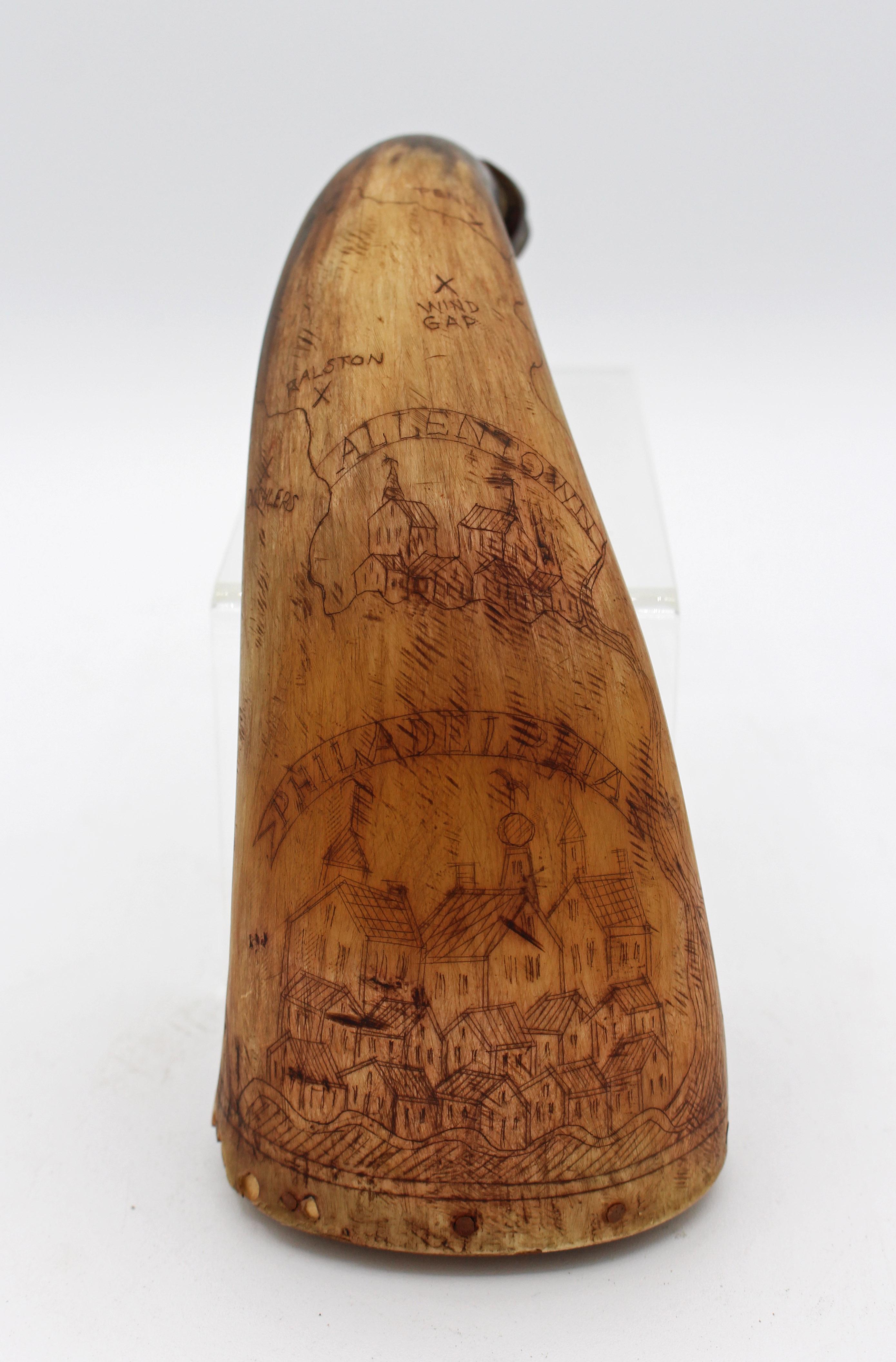 A Pennsylvania etched powder horn, late 18th to early 19th century. Showing a view of Philadelphia and of Allentown with map to various towns wrapping around the horn. End probably replaced (old replacement now well patinated) & edge losses at the