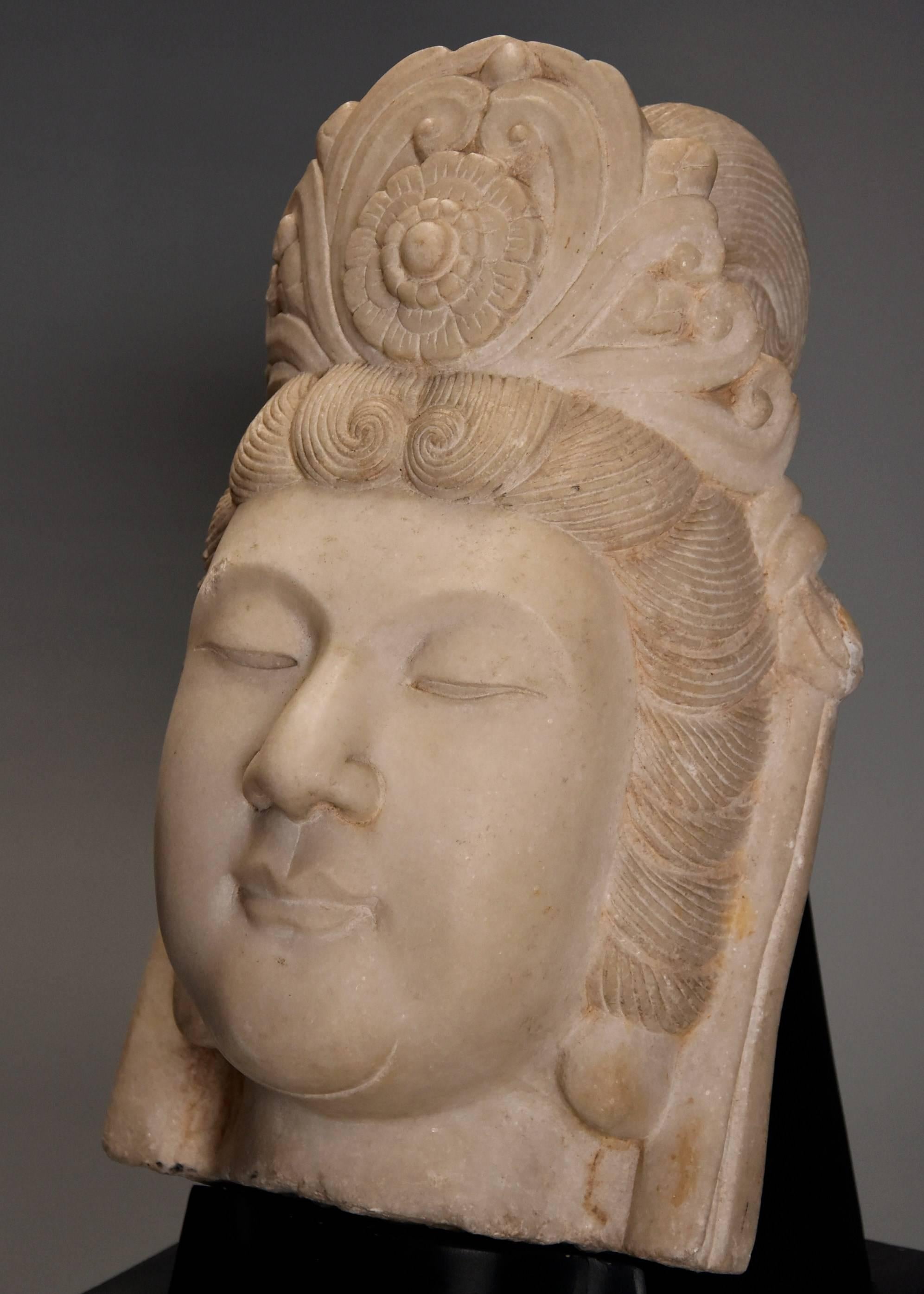 A 20th century highly decorative carved marble head of Guan Yin, on later painted wooden stand.

Guan Yin is known as the Bodhisattva of infinite compassion in East Asian Buddhism, known as the ‘Goddess of Mercy’ in the English language.

This