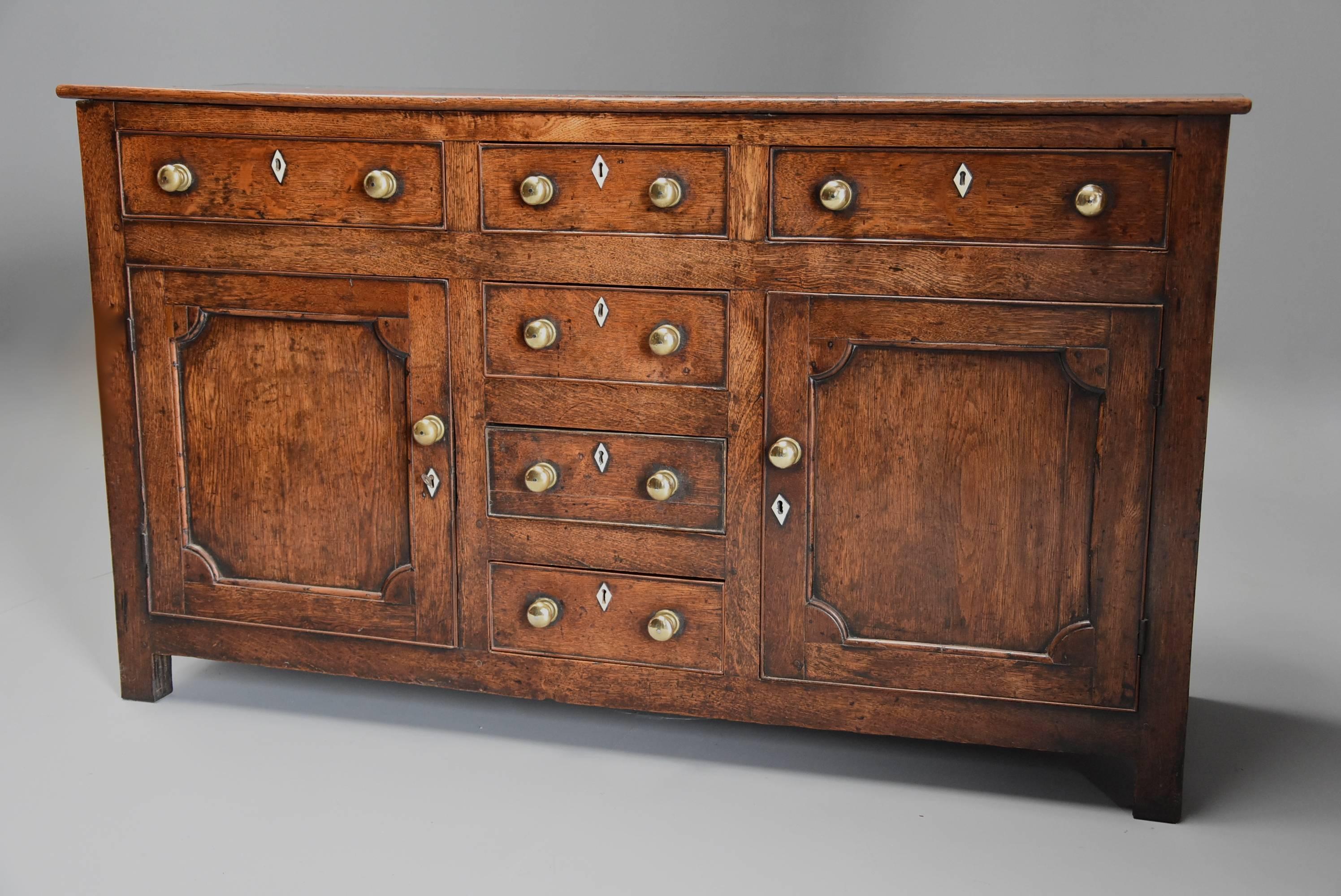 A late 18th-early 19th century oak dresser base of superb patina (color).

This dresser base consists of a solid oak plank top leading down to the front which consists of two long drawers with a bank of four shorter drawers to the centre with a