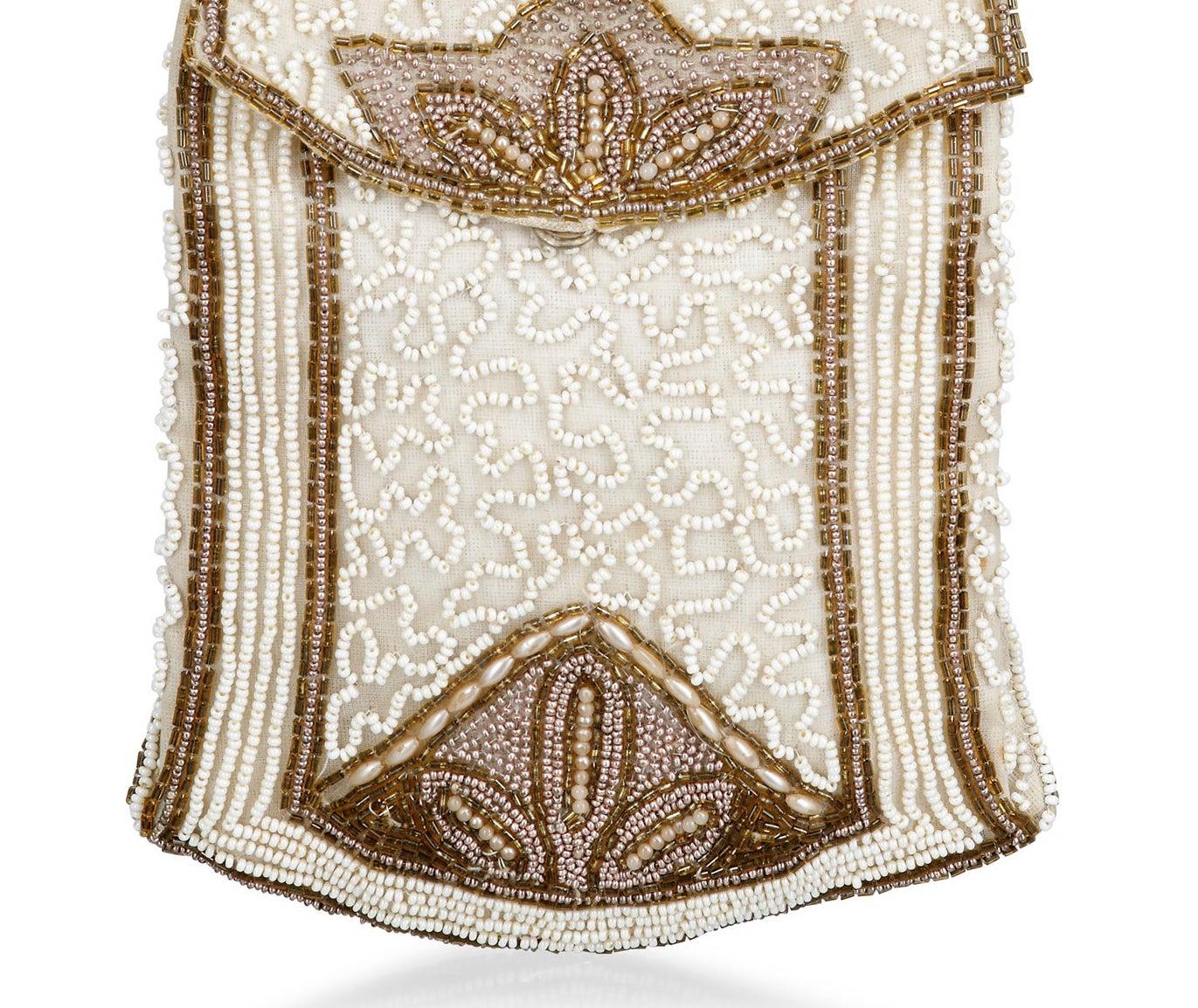 Late 1920s or early 1930s cream and gold beaded handbag. The most striking feature about this bag is that is an unusual spade shape and a rare larger size for one carried by a finger strap.  This darling bag despite being close to 100 years old can