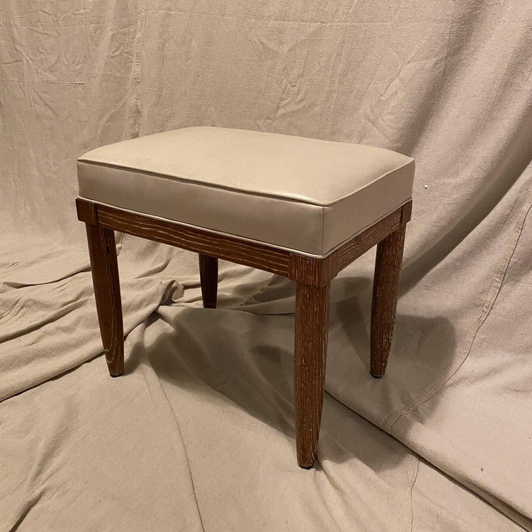 French, late 1940’s Jacques Adnet stool in Cerused white oak purchased from Miguel Saco Inc. in New York City. Upholstered in Ashbury calf hide leather in a warm off white with slight warm gray tones. Perfect as a foot stool or as a pull up seat in
