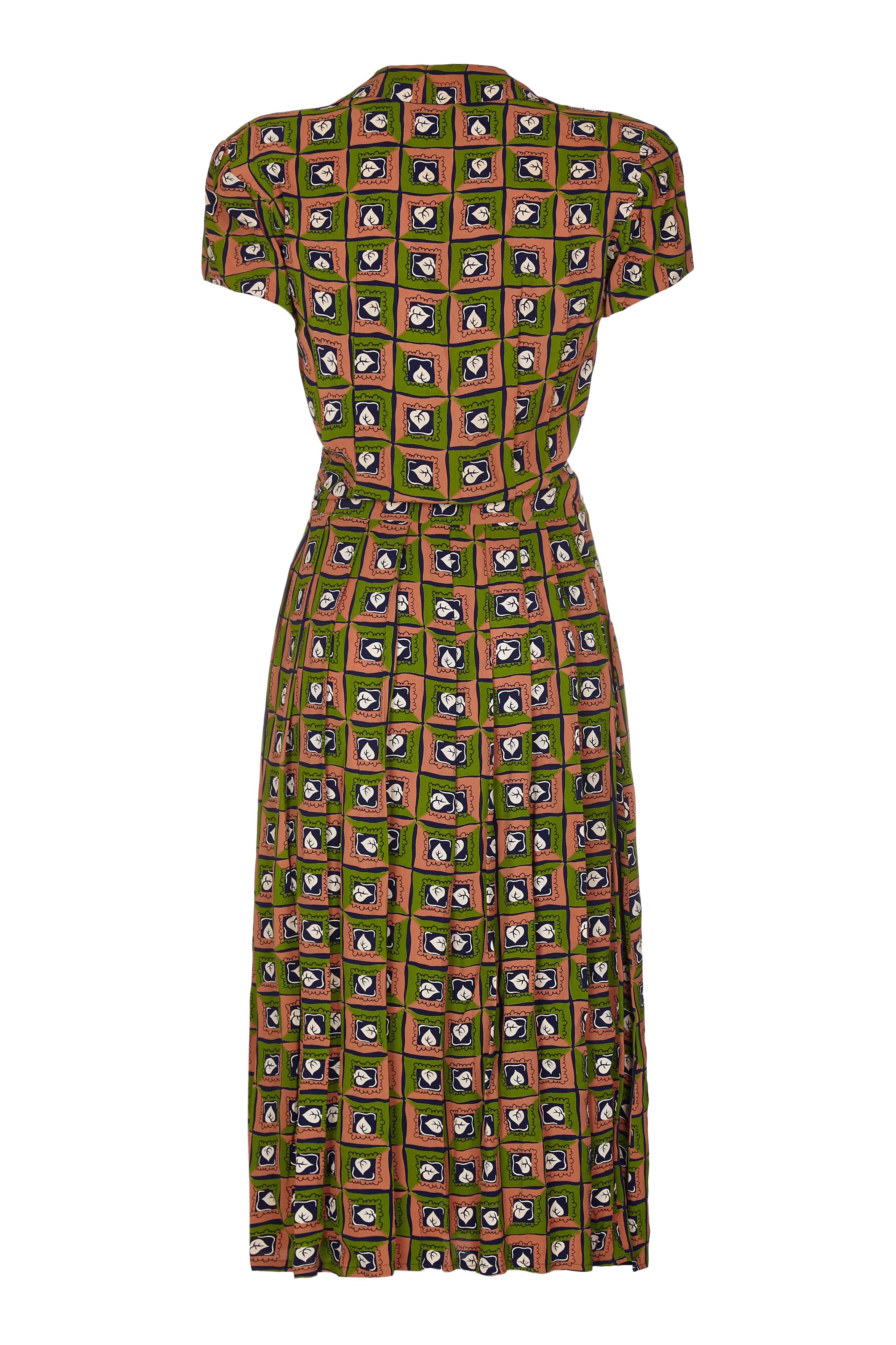 Fabulous Suzy Perette labelled dress with novelty leaf print in navy, green and ochre.  The company was founded during the 1940s and headquartered in New York.  The owner had a licence to copy elements of Christian Dior's designs but they were much