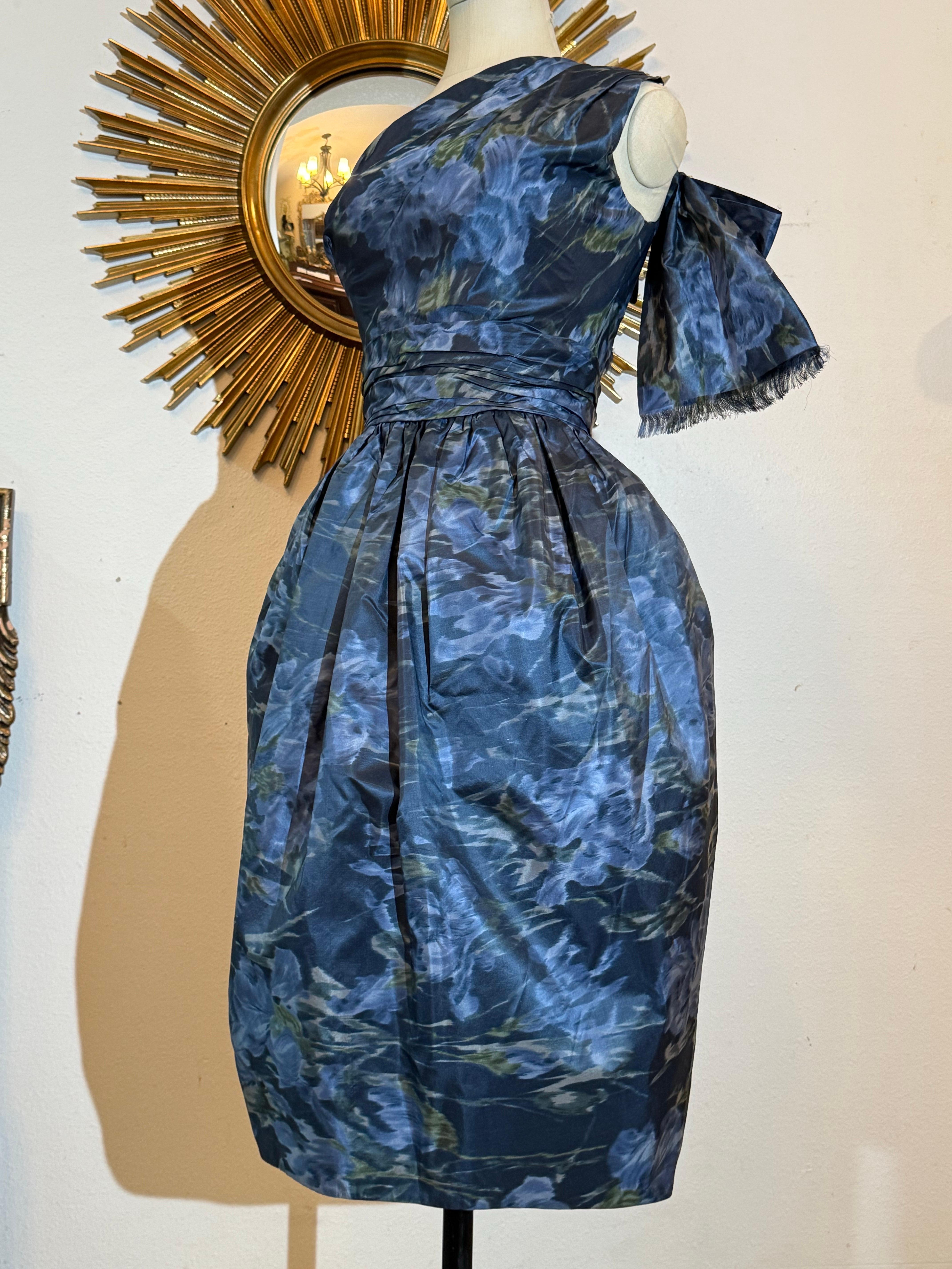 Ende der 1950er Jahre Frederick & Nelson Ein-Schulter-Kleid mit blauem Iris-Moire-Druck:  Cocktailkleid aus gewässertem Seidentaft mit einer extravaganten übergroßen Schleife am hinteren Schulterblatt. Vollständig gefüttert. Taille im