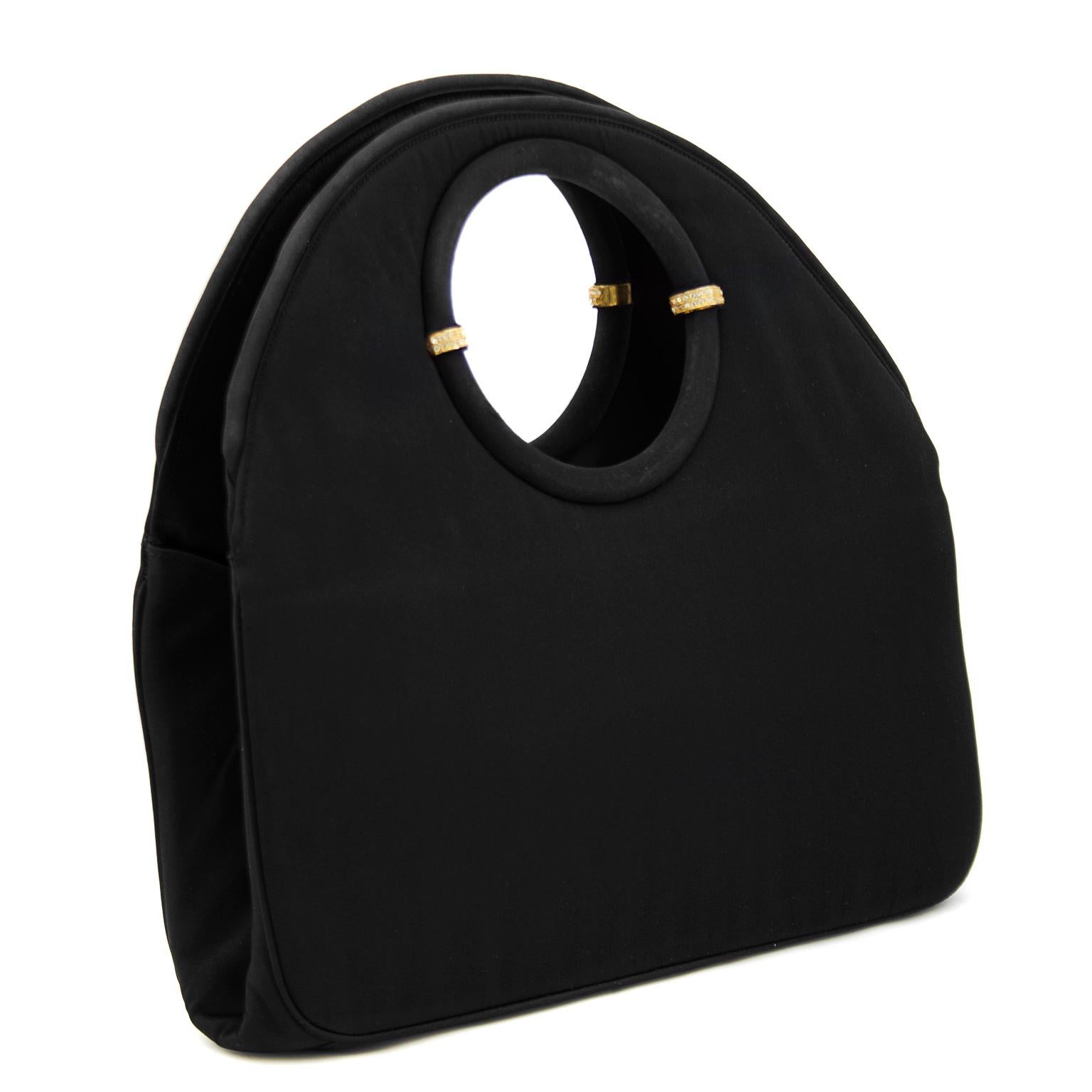Late 1950's Twifaille by Rosenfeld black satin evening bag. The circular handle has gold and rhinestone embellishments along the inside that play up the rounded shape of this bag. The interior is fully lined and opens with two larger pockets on both