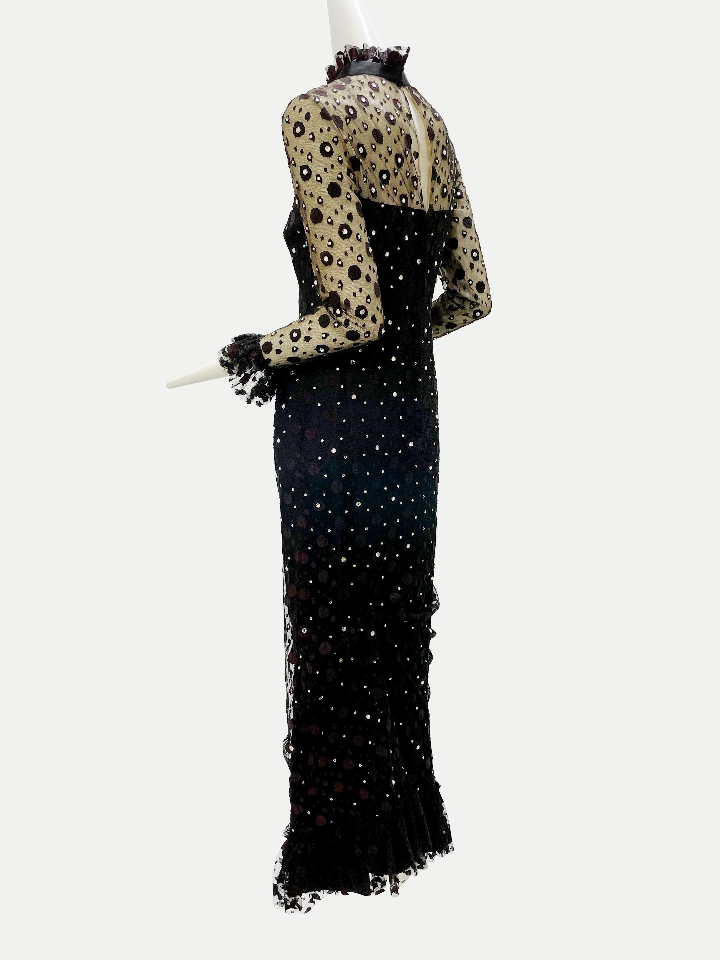 A late 1960s black maxi dress with rhinestone dotted tulle overlay:  Underlayer in black satin with a sweetheart neckline. Overlay is dotted tulle with prong-set rhinestone embellishment and ruffled, banded collar, cuffs and hemline. Fits a modern