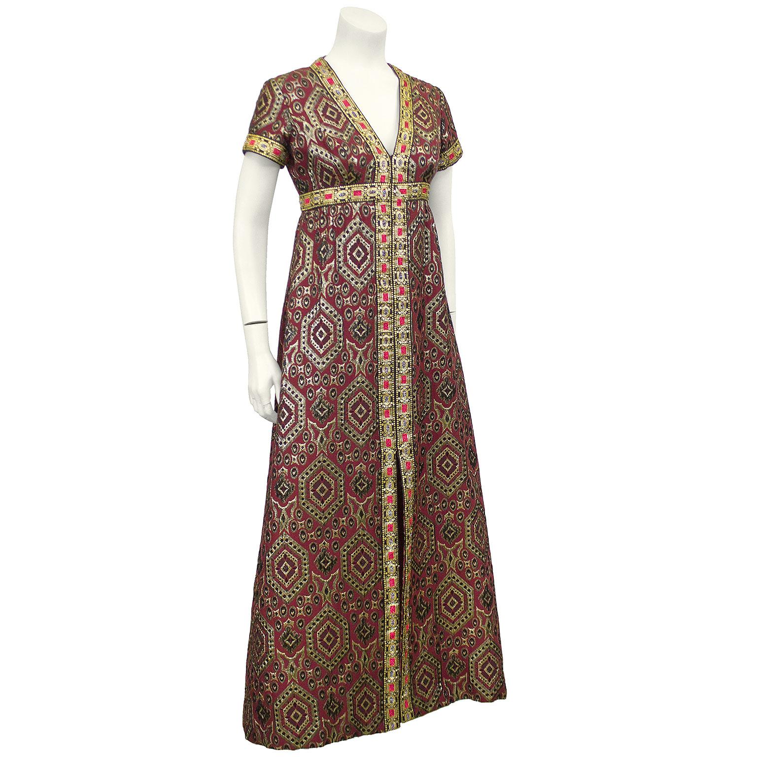 Although no label is found I am confident this dress can be attributed  to Oscar de la Renta. Having sold many of his gowns from the same era, this gown is a real ODL showstopper. Made from a heavy burgundy brocade with an intricate gold, silver and