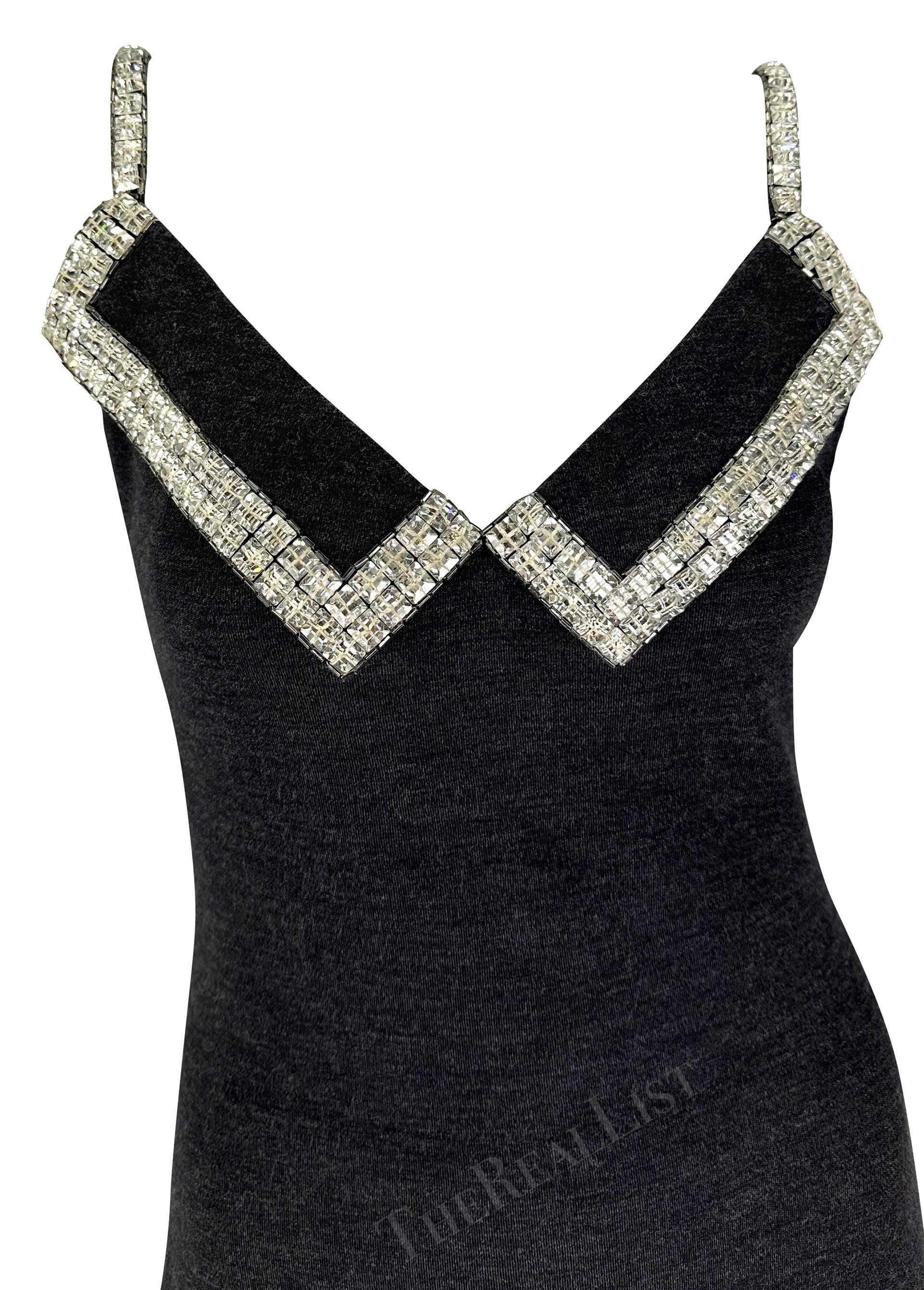 Presenting a chic heather grey James Galanos gown. From the late 1980s, this classicly sexy knit dress features a v-neckline, fold over detail at the bust, and a low exposed back. The dress is made complete with square rhinestone accents at the bust