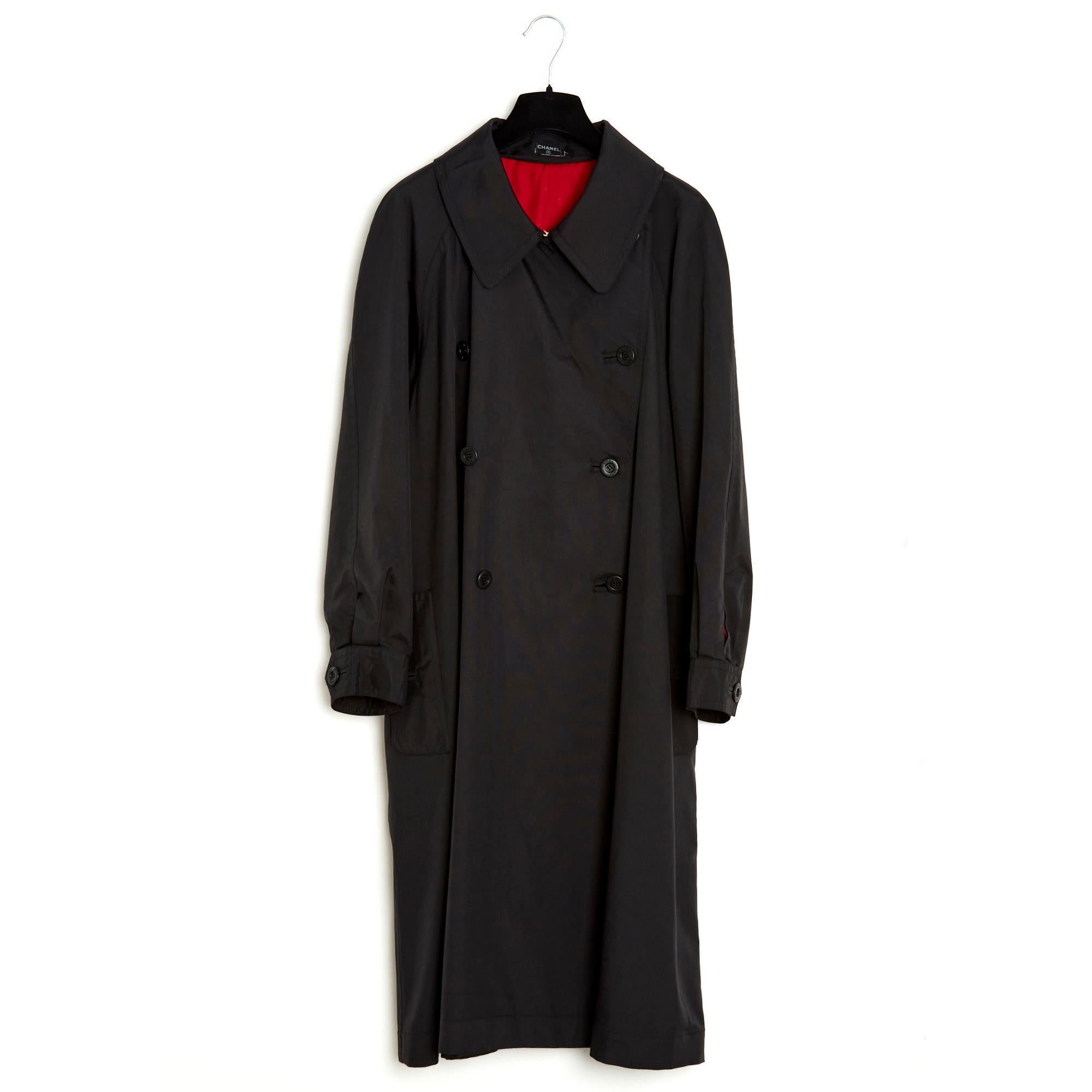 Chanel trench coat in black silk rep, wide collar closed with a gold hook, double breasted Chanel logo on the front, 2 slit pockets closed with a button, long raglan sleeves closed with 2 buttons, large full-length box pleat at the back , bright red