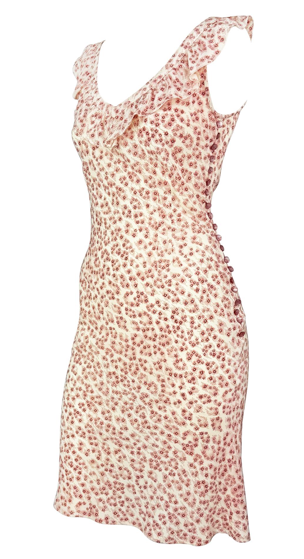 Diseñado a finales de los 90 durante la etapa de Stella McCartney en Chloé, este vestido midi sin mangas presenta un suave estampado floral rosa sobre seda crema. Los detalles incluyen un escote con volantes y una hilera de botones cubiertos de