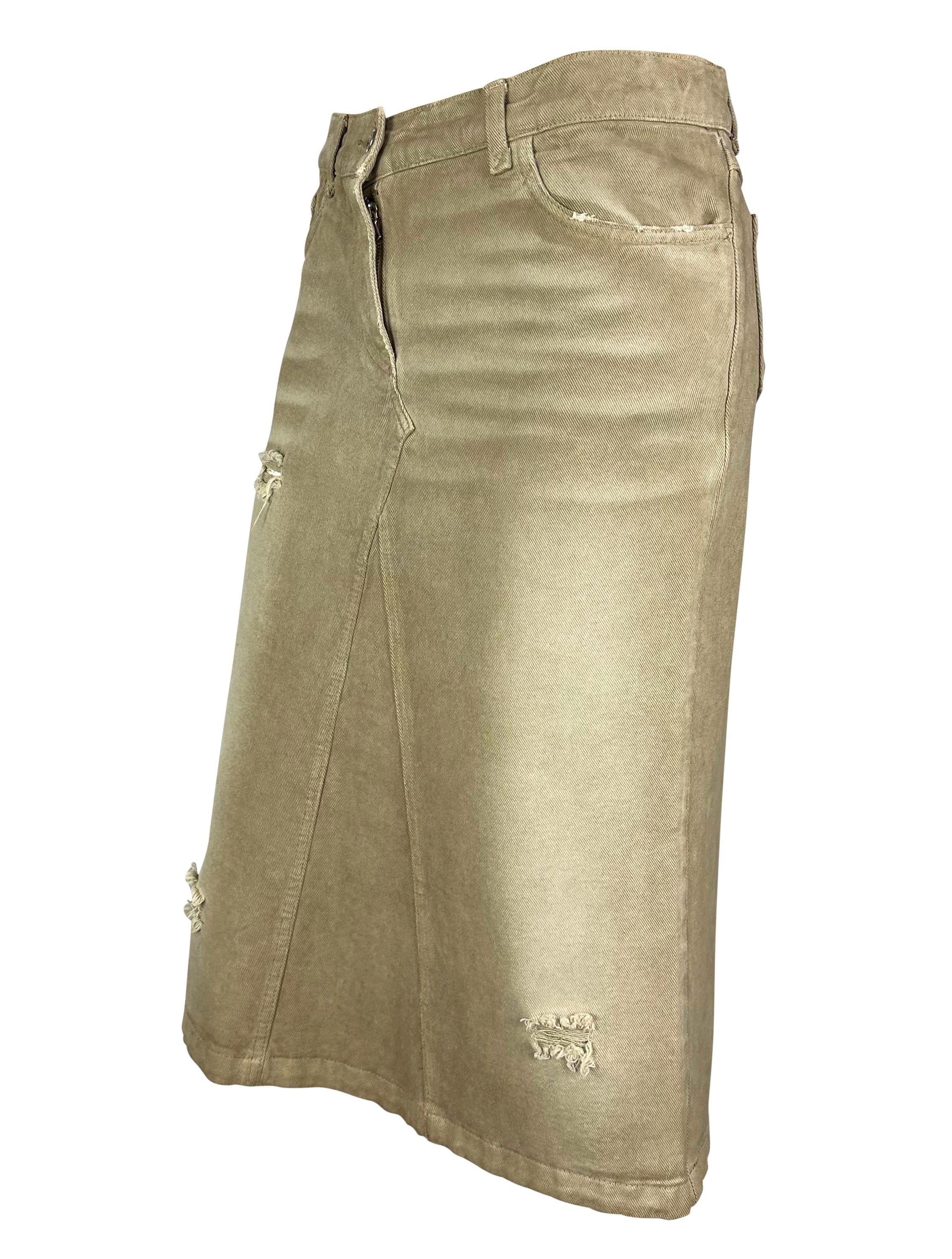 Ti presentiamo una favolosa gonna in denim distressed beige di Dolce & Gabbana. Questa gonna midi vintage, risalente alla fine degli anni '90, è volutamente rovinata e realizzata in modo da sembrare un jeans rielaborato. Aggiungi questa gonna chic