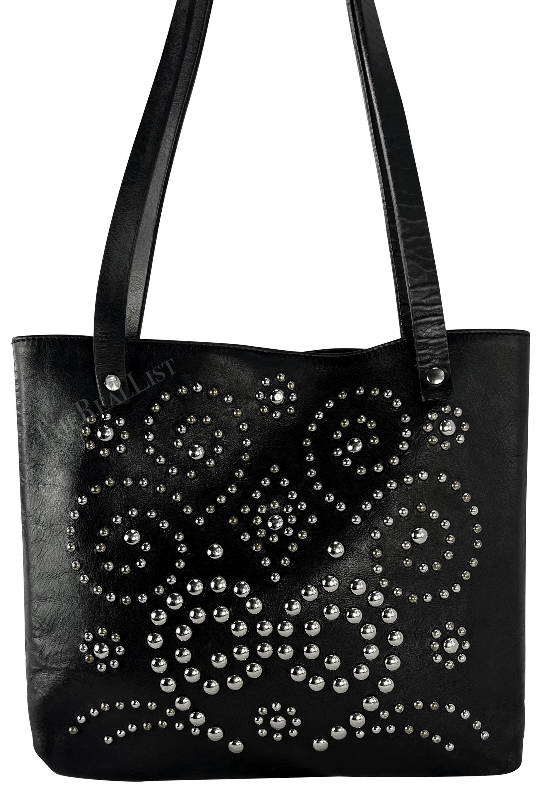 A chic black leather studded Dolce & Gabbana tote from the late 1990s. This small black leather tote features elevated style with silver studs arranged in an scrolling pattern. The perfect elevated take on a closet staple, this small Dolce & Gabbana