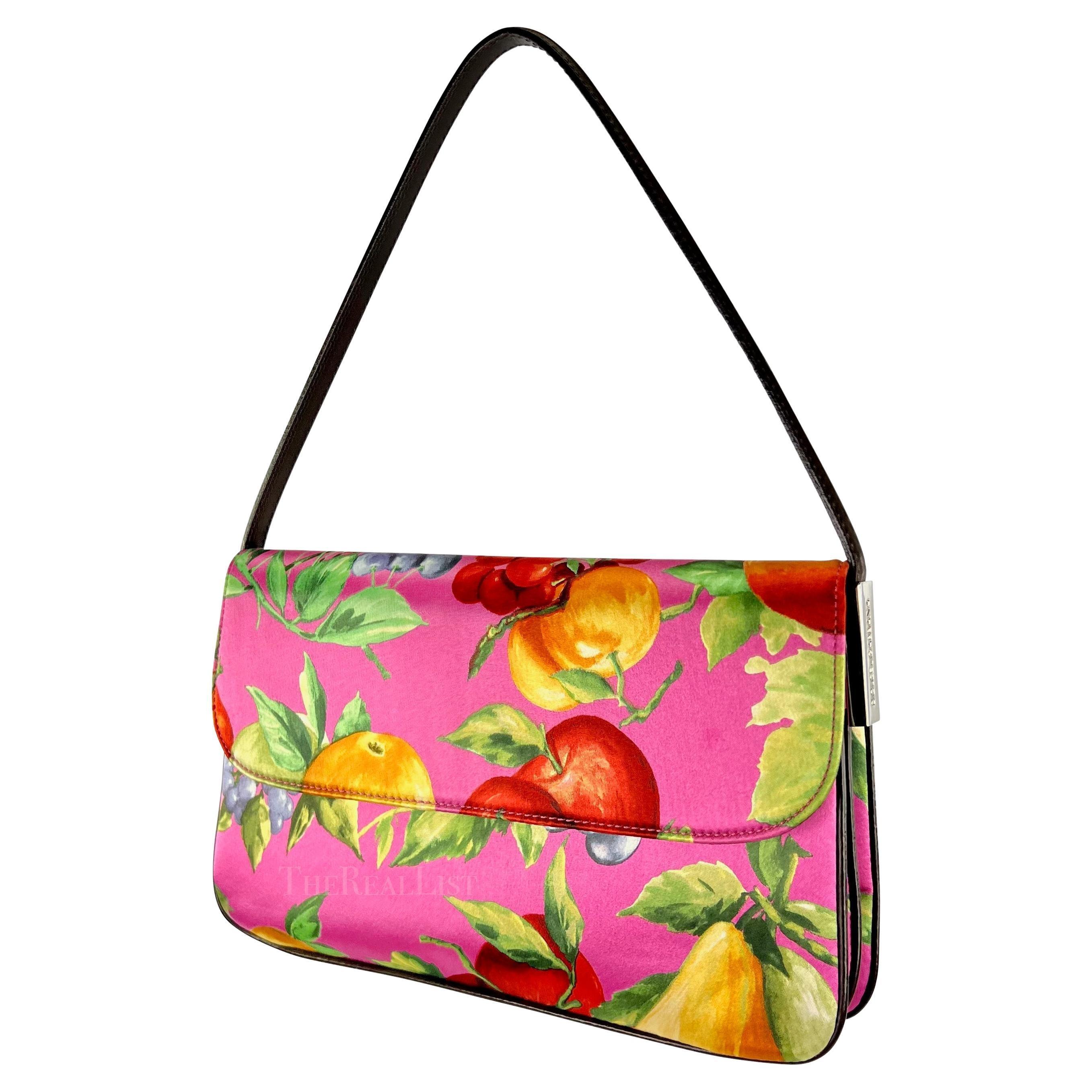 Ti presentiamo una favolosa borsa a tracolla con patta di Dolce & Gabbana in raso rosa con stampa di frutta. Prova il fascino favoloso di questa borsa a tracolla con patta di Dolce & Gabbana in raso con stampa di frutta rosa, un tesoro straordinario