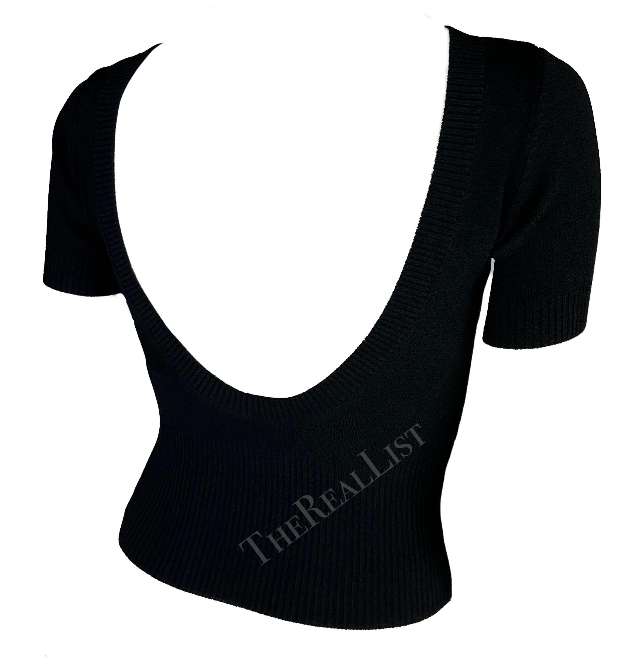 Voici un haut à manches courtes chic en tricot noir Dolce & Gabbana. Datant de la fin des années 1990, ce pull-over présente une encolure haute et est complété par un dos apparent. 

Mesures approximatives :
Taille - 42IT
De l'épaule à l'ourlet :