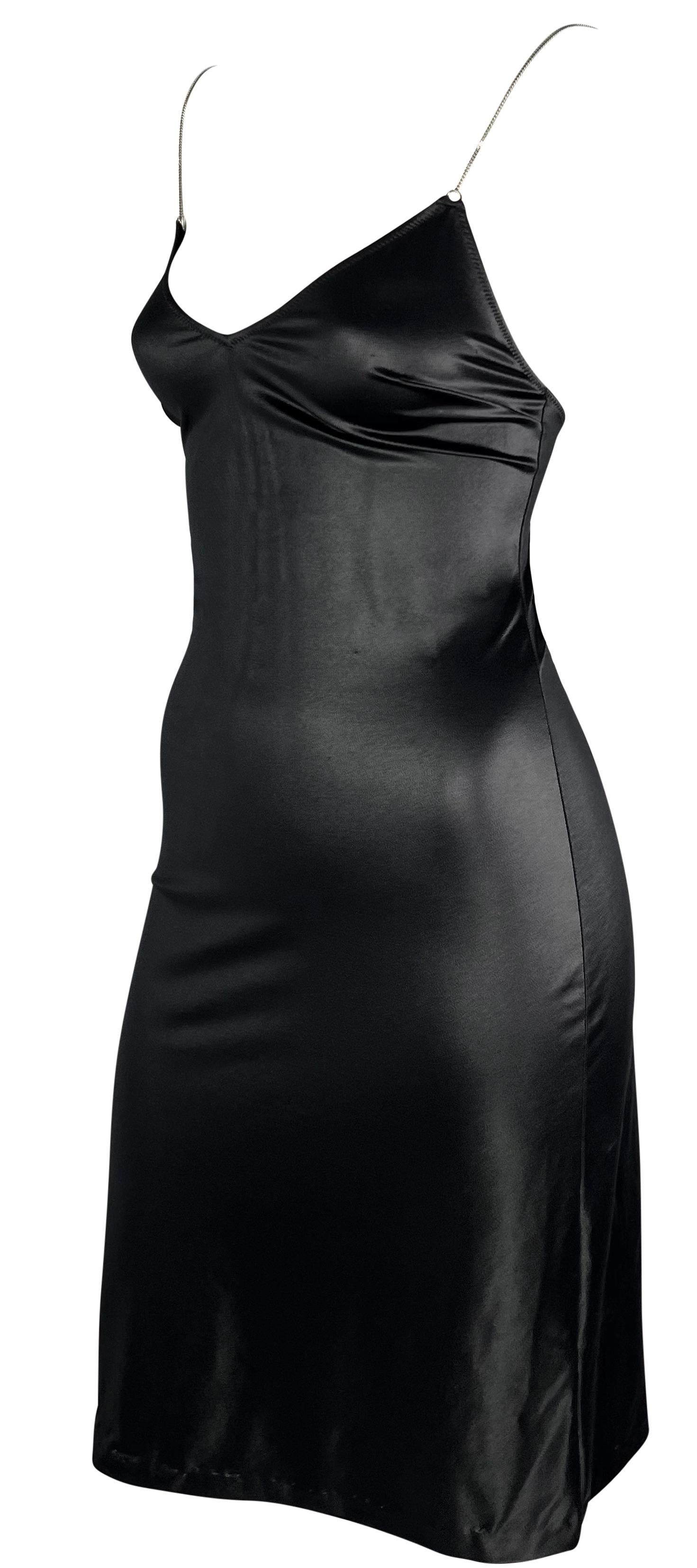 This shiny black Dolce & Gabbana mini dress perfectly clings to the body. This wet look slip-style dress from the 1990s features a low neckline and back. The dress is made complete with thin silver-tone chain straps. 

Approximate measurements:
Size