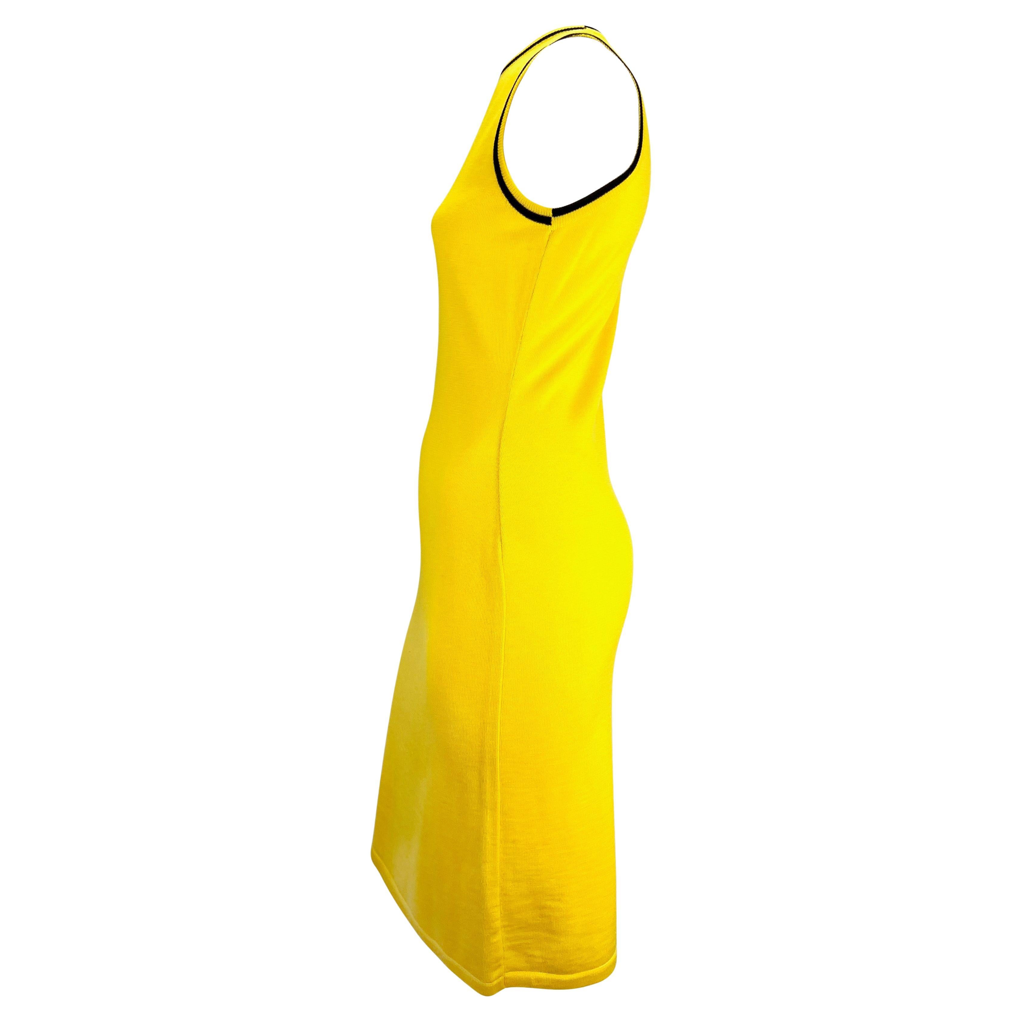 Présentation d'une robe sans manches en maille jaune canari de Gianni Versace. Datant de la fin des années 1990, cette robe élégante et formulée entièrement en laine tricotée est ornée d'une bande noire autour de l'encolure et des emmanchures. D'une