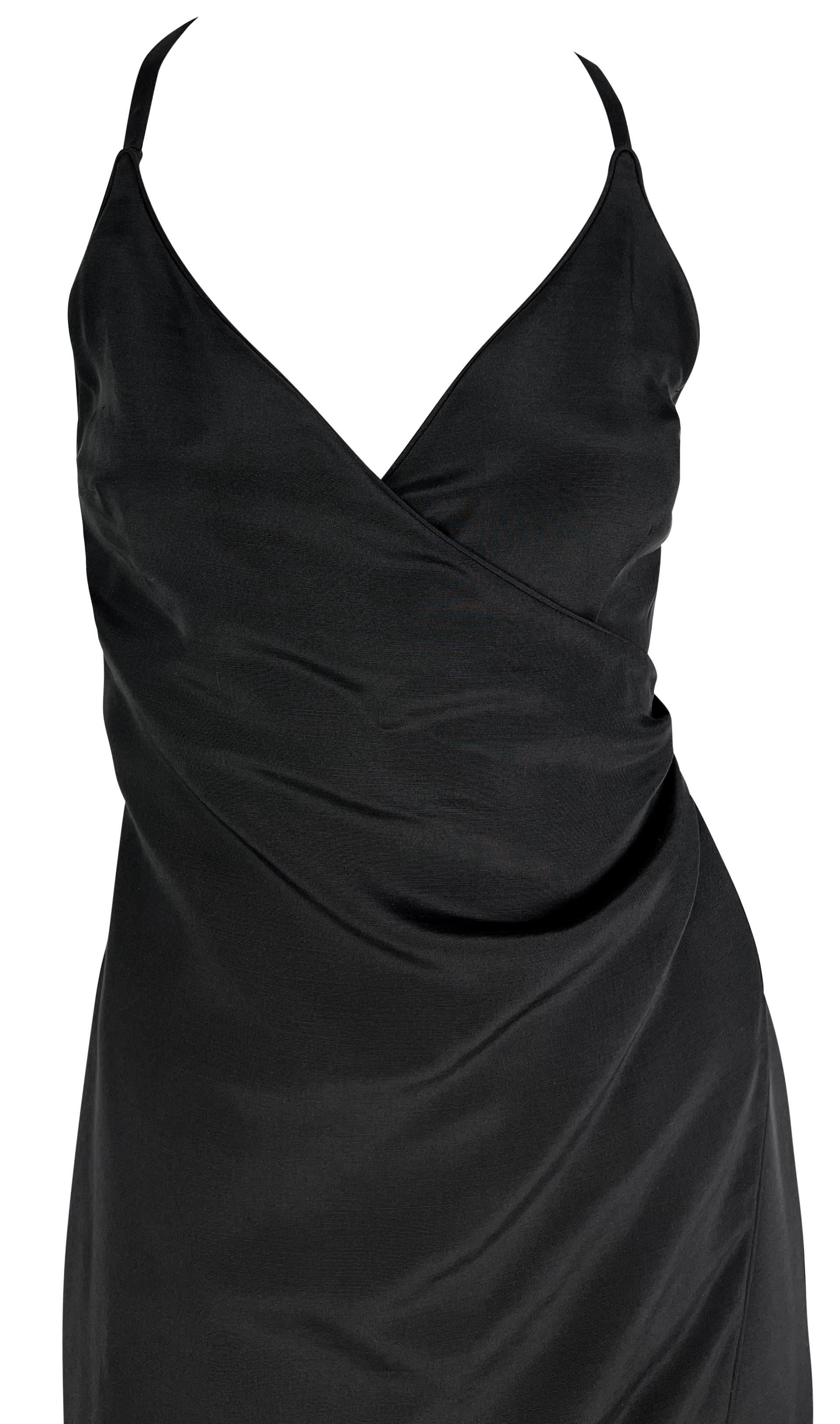 Questo abito nero di Giorgio Armani, risalente alla fine degli anni '90, incarna un'eleganza elevata. Il design a sottoveste presenta una finta fascia che si stringe su un lato della vita, completata da una scollatura a V e da una schiena scoperta.